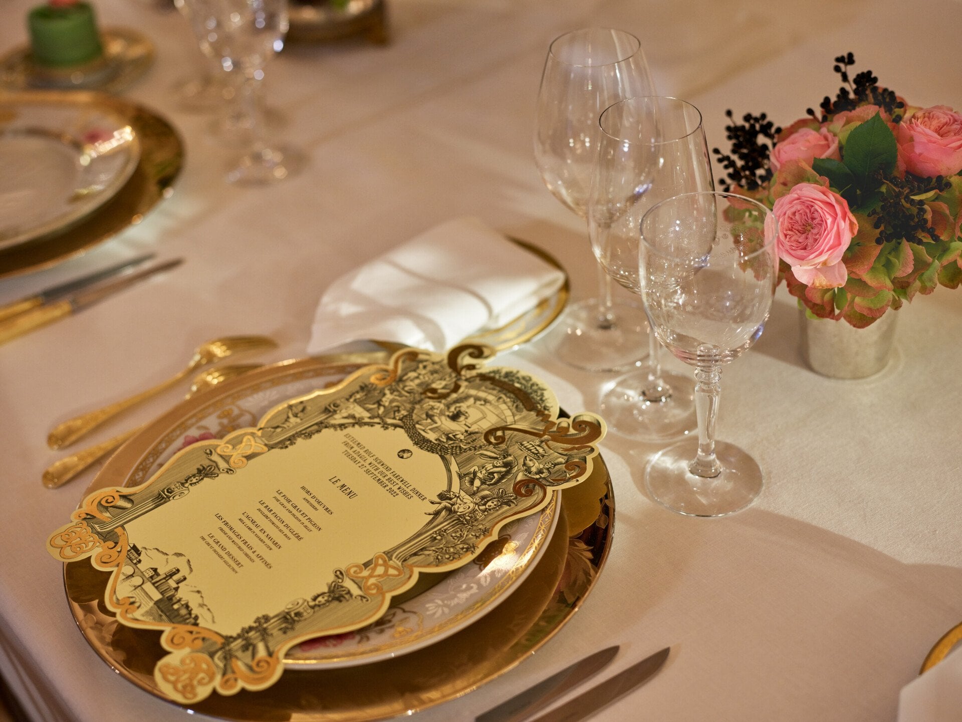 Menu captured with gold and white tableware, pink and green flowers, green cakes, at Le Salon Organza, at Hôtel Plaza Athénée, Paris - Dorchester Collection.