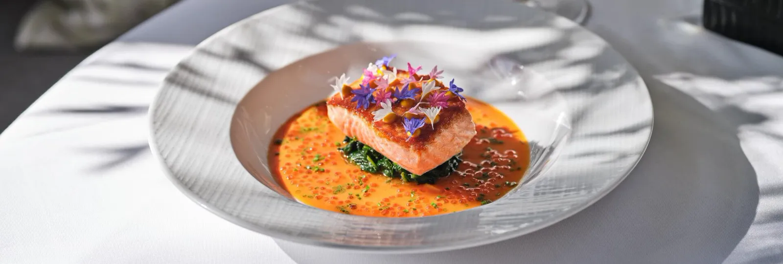 Bright orange salmon with greens main dish from The Restaurant at Hotel Bel-Air