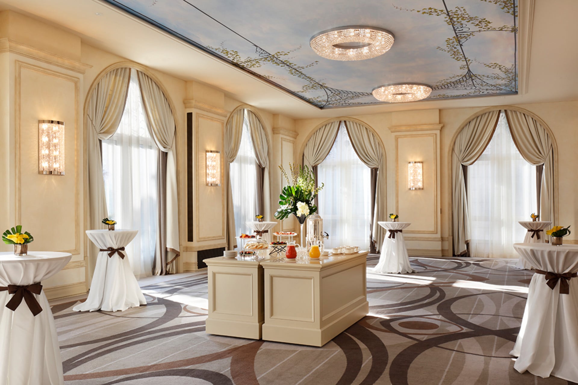 Our Veranda meeting room furnished with high tables along the sides and, in the centre, a table with refreshments, fruit and pastries