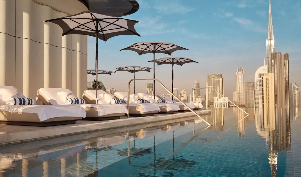 The Lana rooftop pool with sunlongers and view of Downtown Dubai