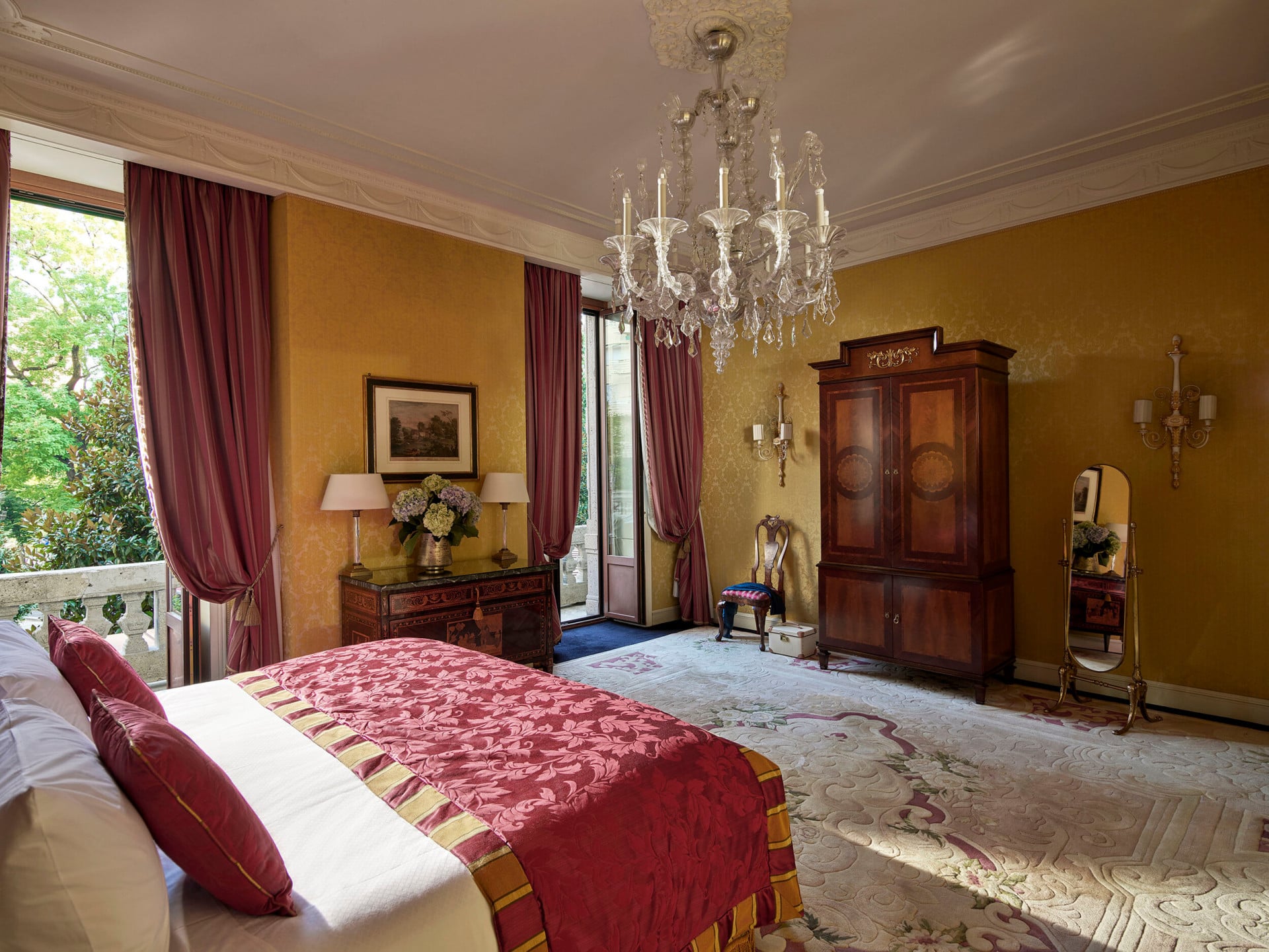 Camera da letto della Royal Suite caratterizzata dall'elegante lampadario e illuminata da luce naturale proveniente dalle due finestre 