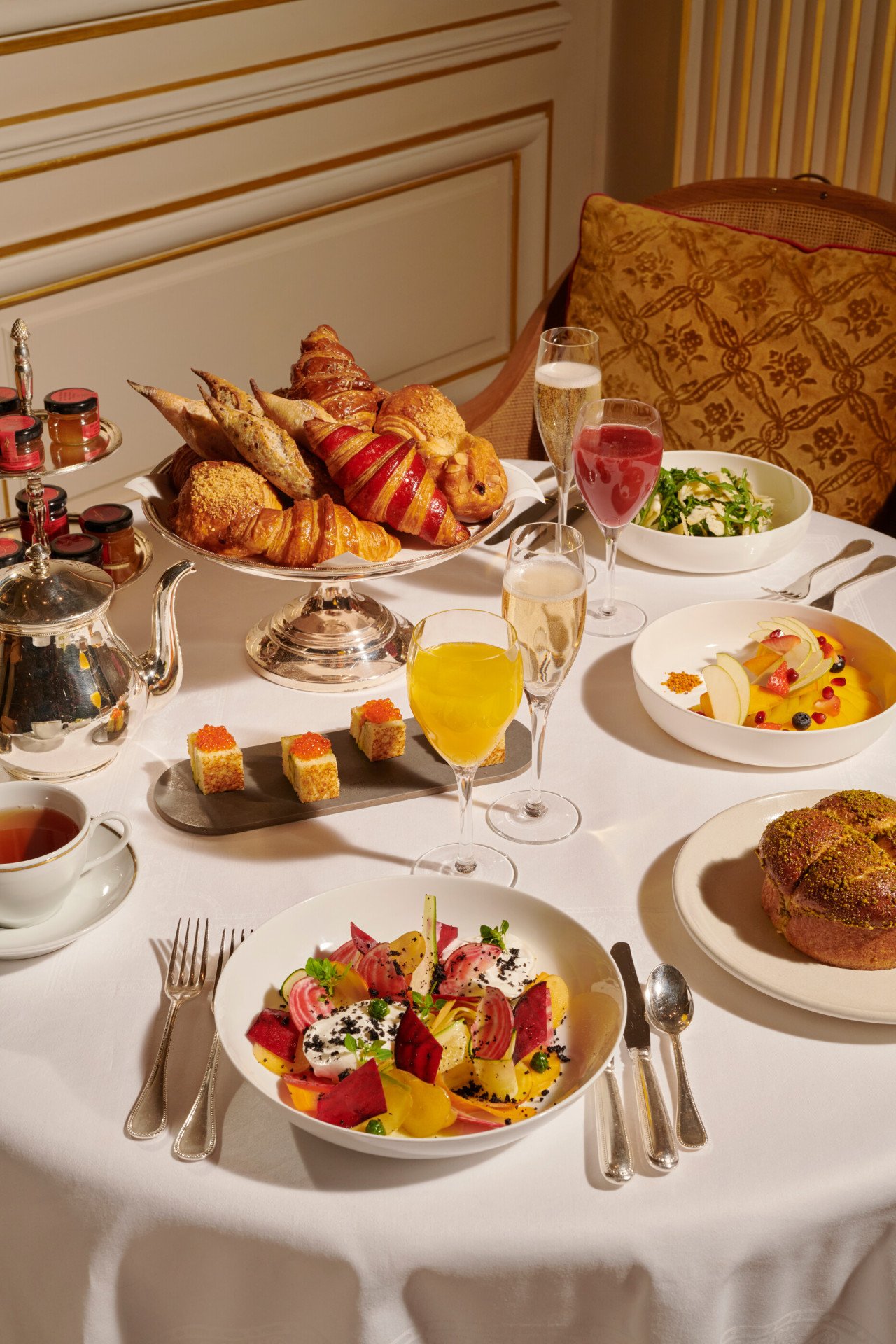 Imagens do brunch no Jean Imbert au Plaza Athénée. Podemos ver pastelaria, saladas, frutas, suco de laranja e um pouco de champanhe 