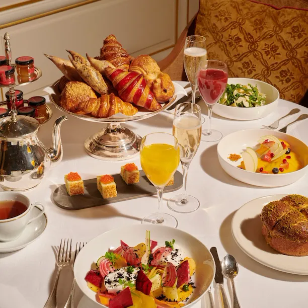 Imagens do brunch no Jean Imbert au Plaza Athénée. Podemos ver pastelaria, saladas, frutas, suco de laranja e um pouco de champanhe