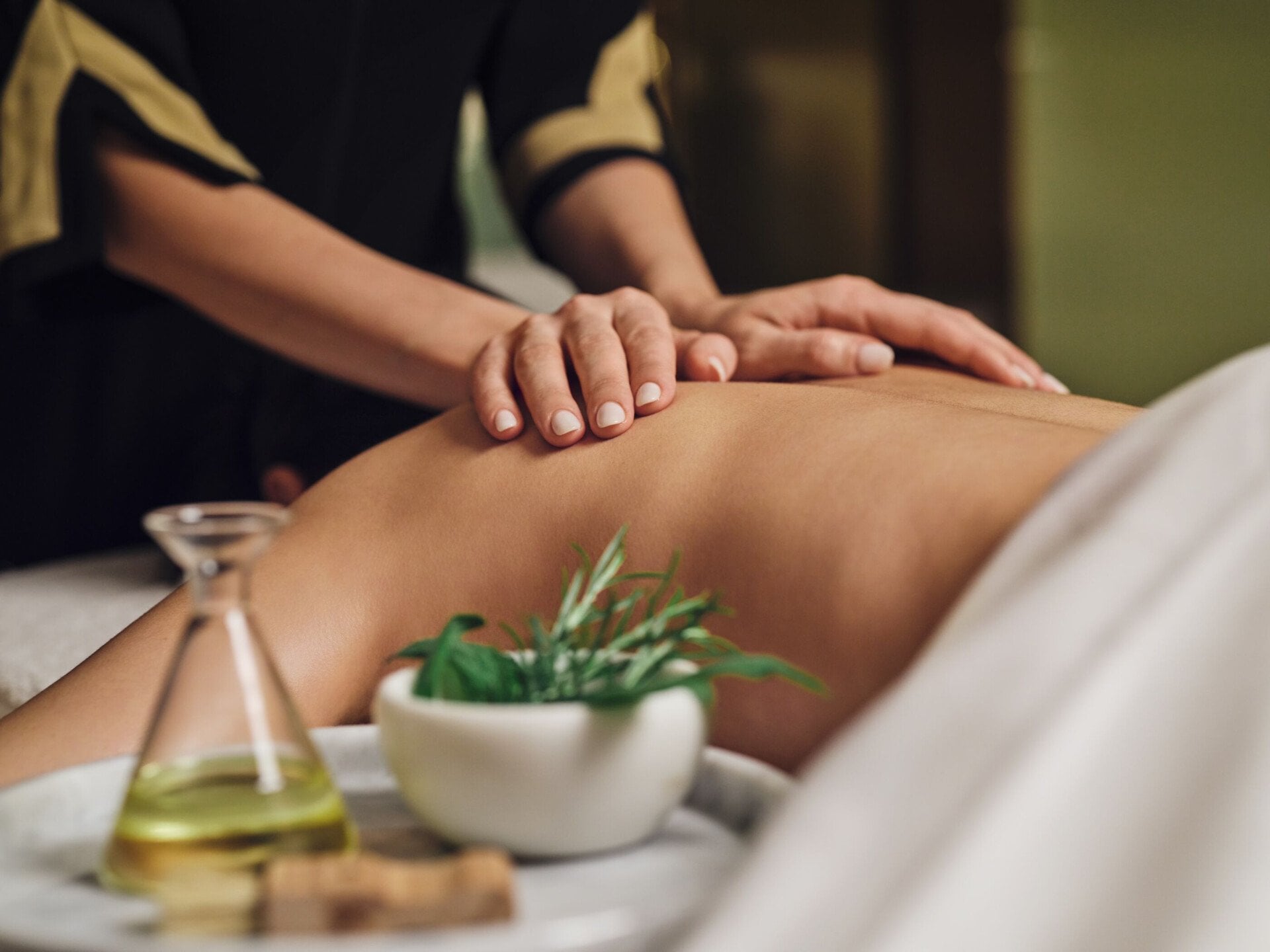 Terapista che massaggia la schiena di una donna distesa a The Eden Spa