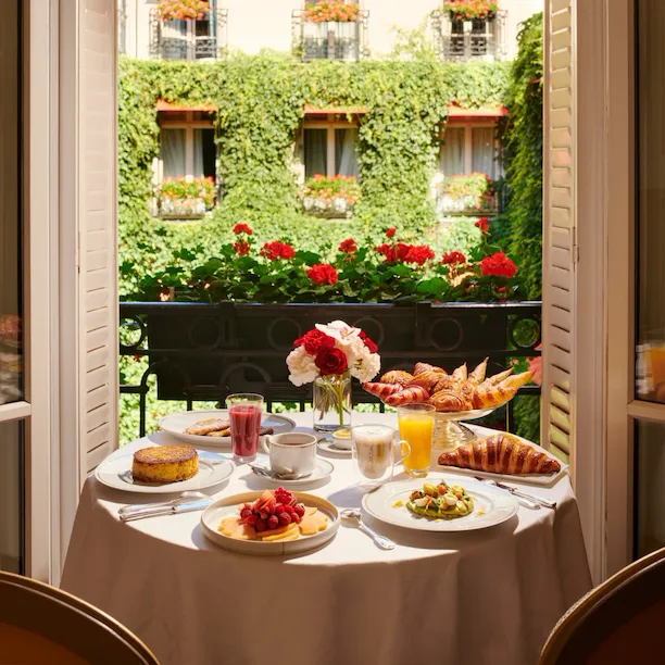 Imagens do brunch na sala com bolos e frutas frescas com vista para o La Cour Jardin