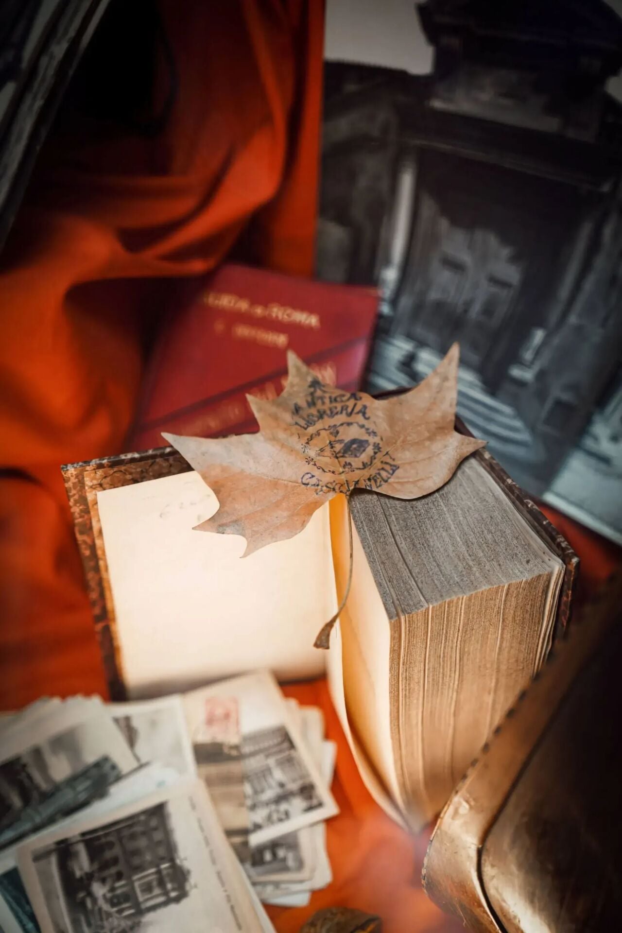 Libro d'antiquariato  appoggiato aperto in verticale su cartolina antiche