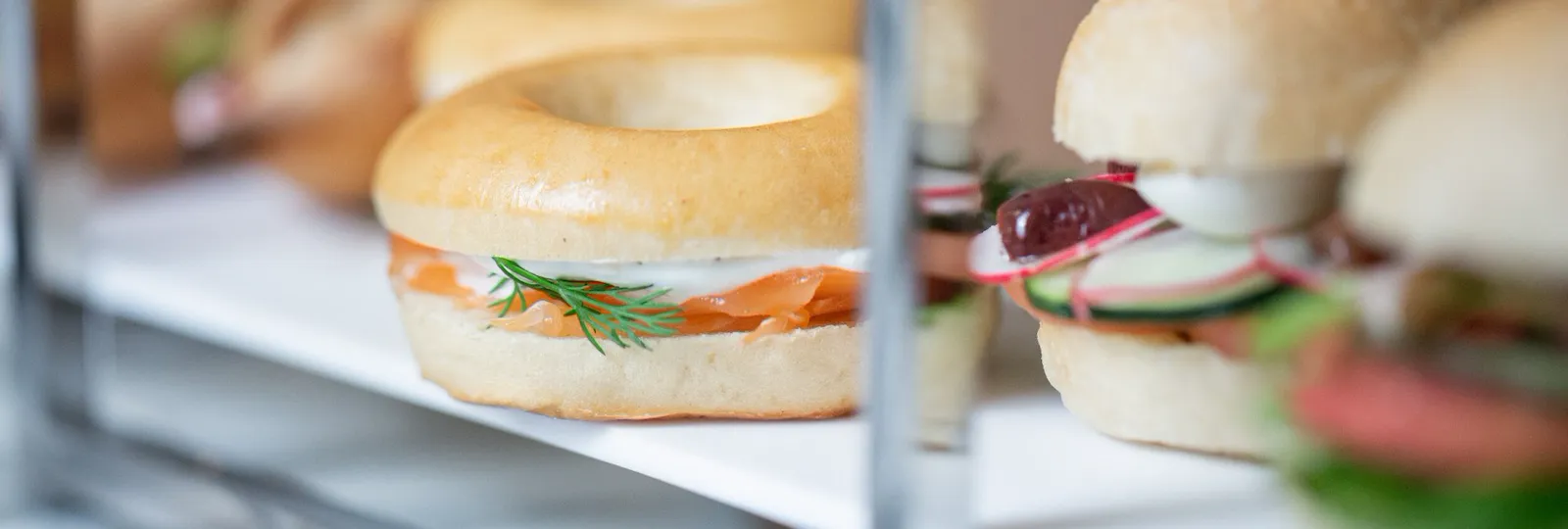 Closeup shot of finger sandwhiches, with a focus on a salmon bagel with cream cheese. At Restaurant le Dali, at Le Meurice, Paris.