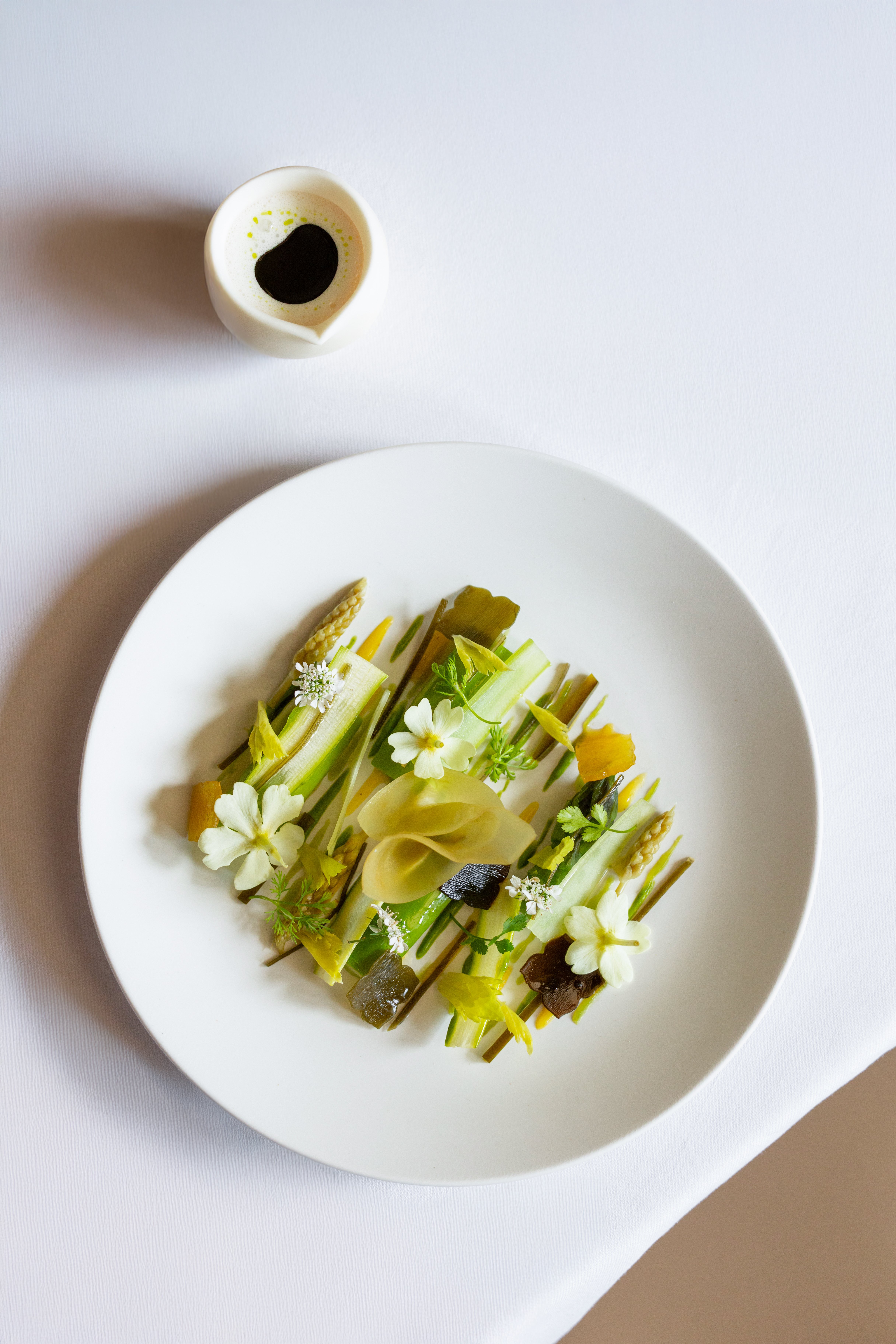 Green aspargus in a white plate served at Le Meurice Alain Ducasse. 