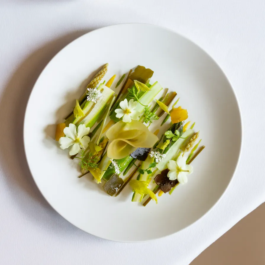 Green aspargus in a white plate served at Le Meurice Alain Ducasse.