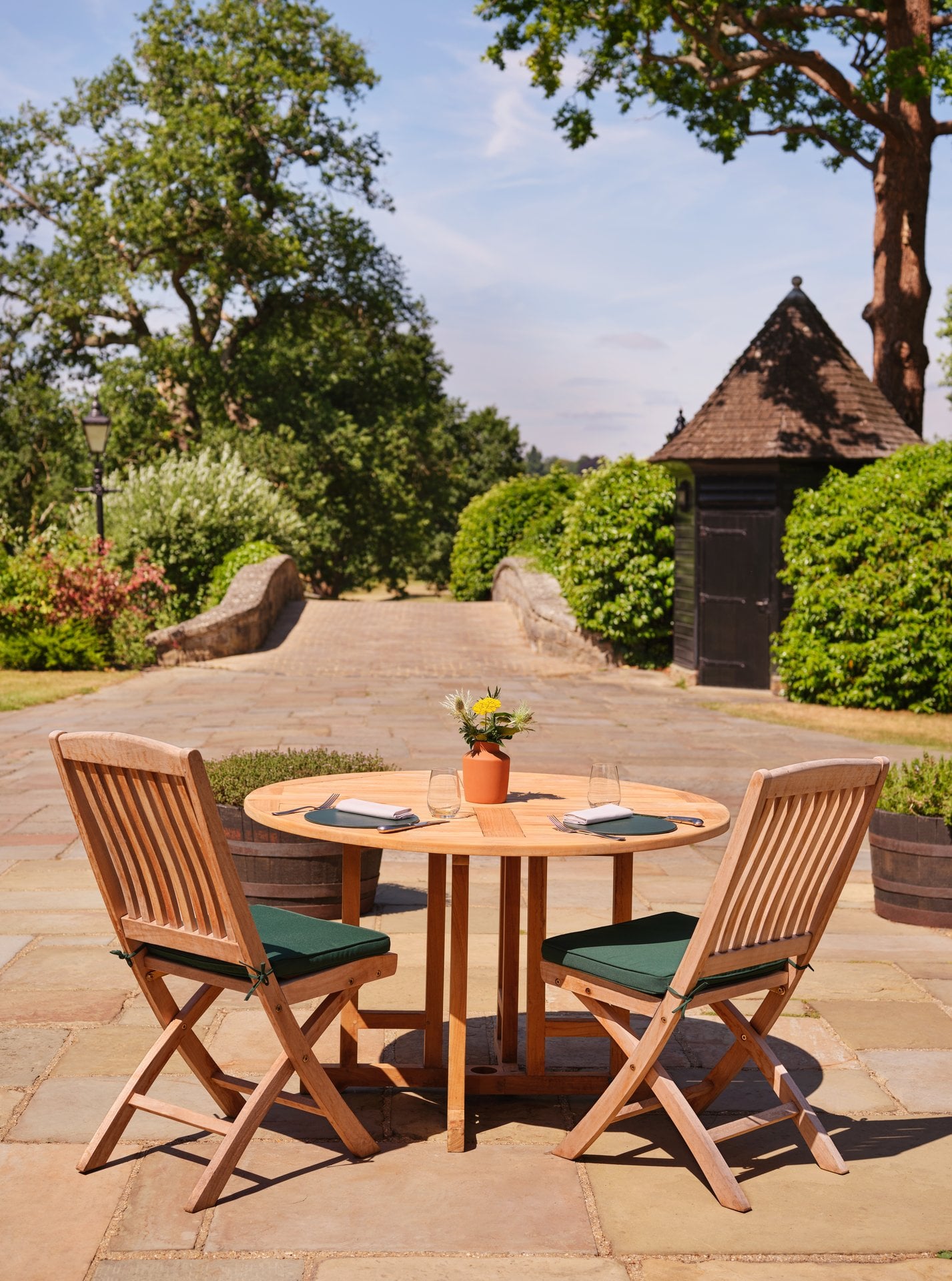 Al fresco dining terrace at The Barn at Coworth Park overlooking the gardens