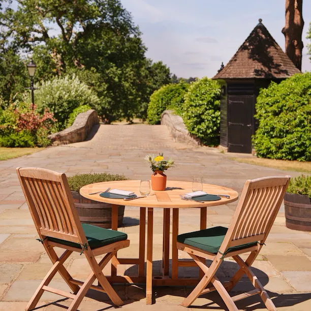 Al fresco dining terrace at The Barn at Coworth Park overlooking the gardens
