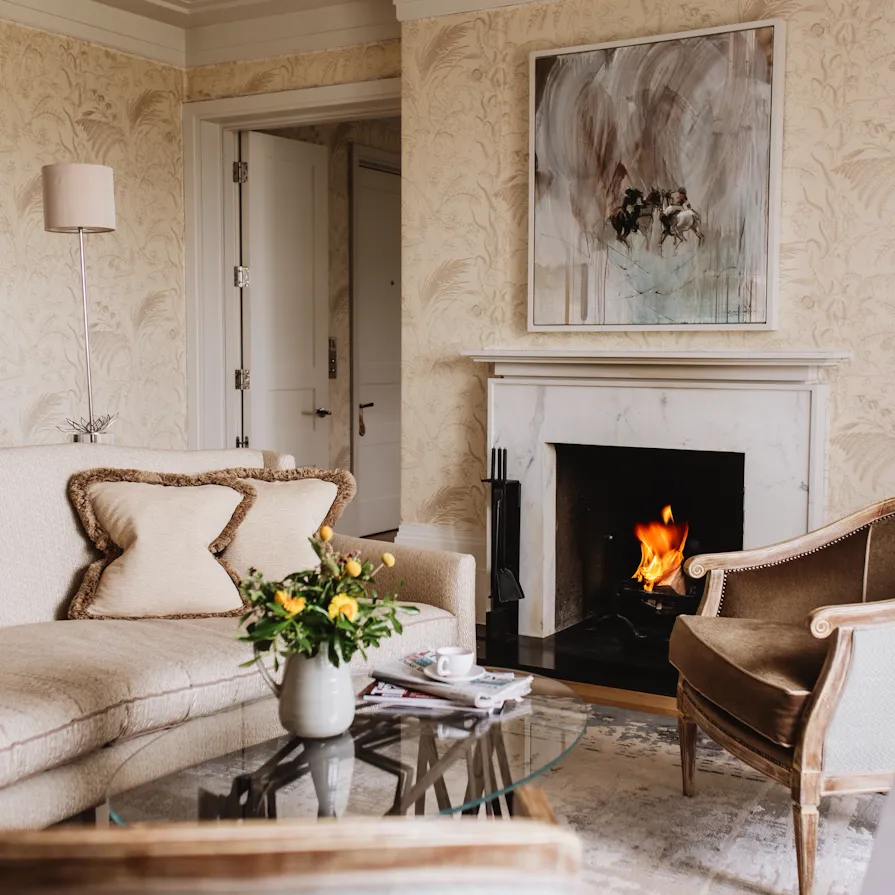 Mansion House suite with marble fireplace and elegant seating at Coworth Park, Ascot