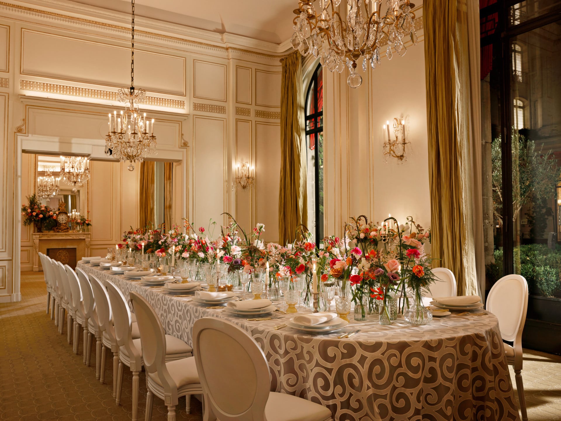 Long table set up with grey tablecloth, colorfull flowers captured in Le Salon Organza, at Hôtel Plaza Athénée, Paris - Dorchester Collection.