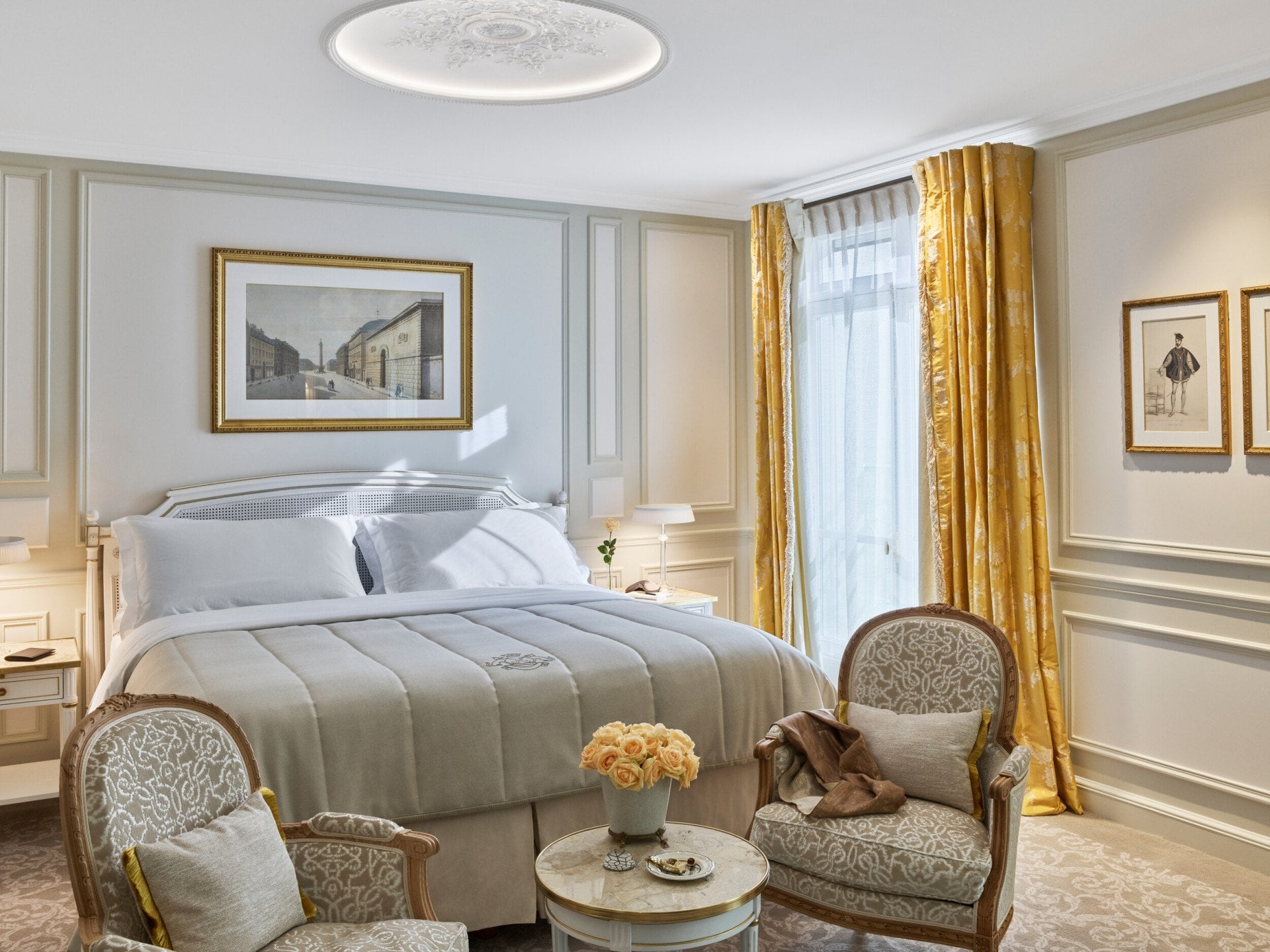 Quarto executivo em tons de bege, cortinados amarelos e amarelo-rosa, duas cadeiras em frente à cama. Au Meurice, Paris.