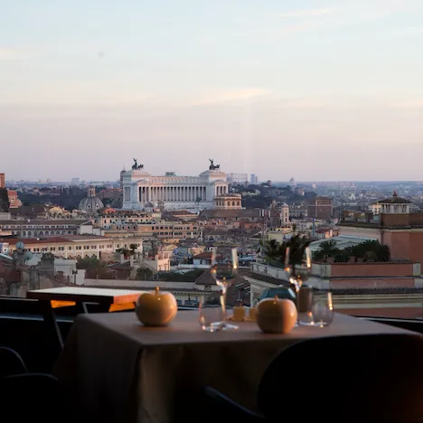 Tavolo per due davanti la vetrata del ristorante La Terrazza con vista sul Vittoriano a Roma