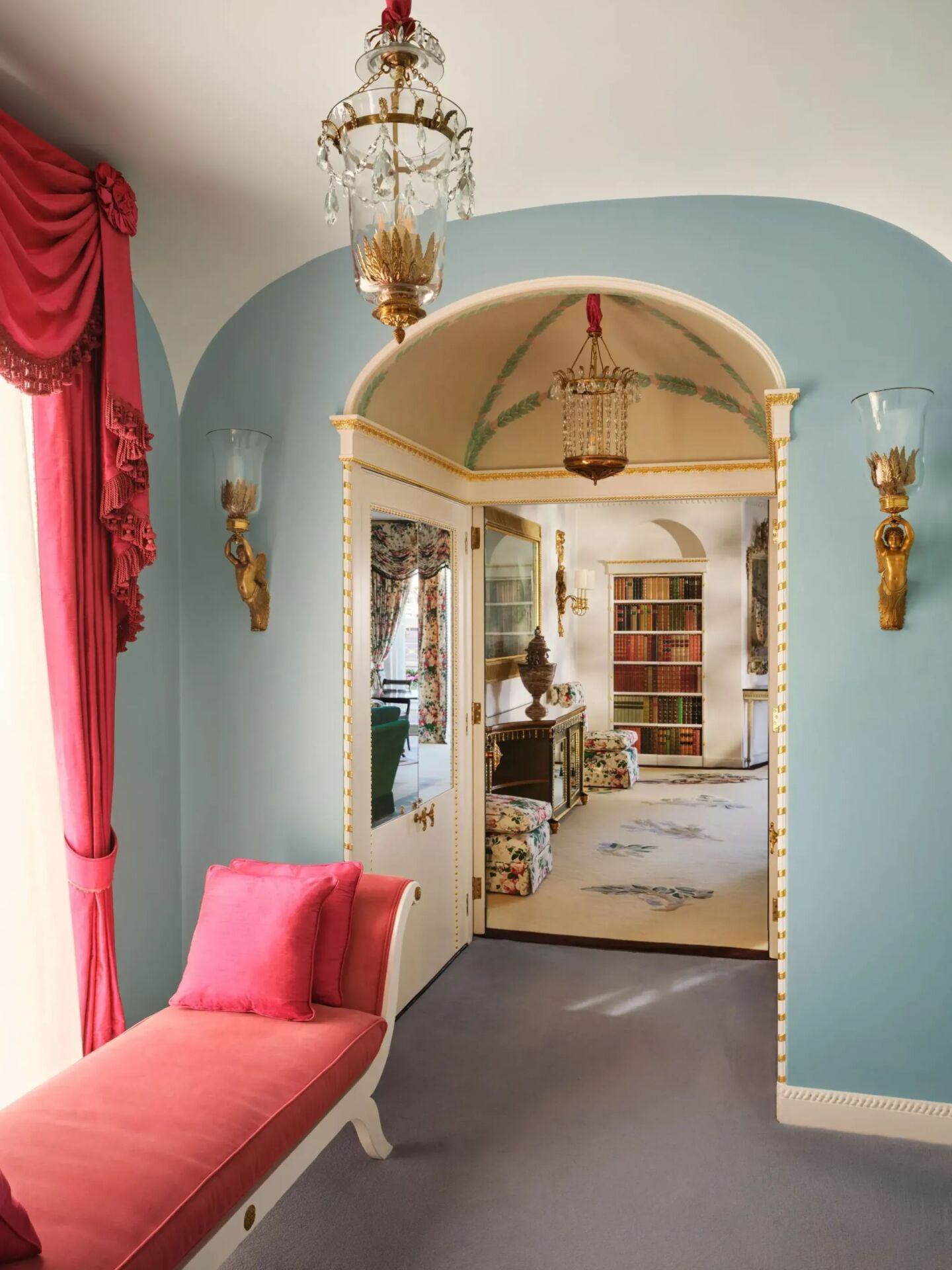 An elegant hallway leading to a living area with bookshelves