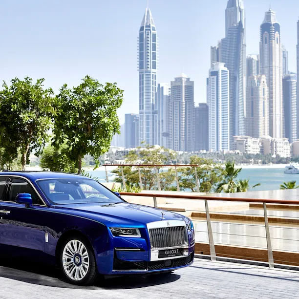 Blue rolls royce car with Dubai skyline background