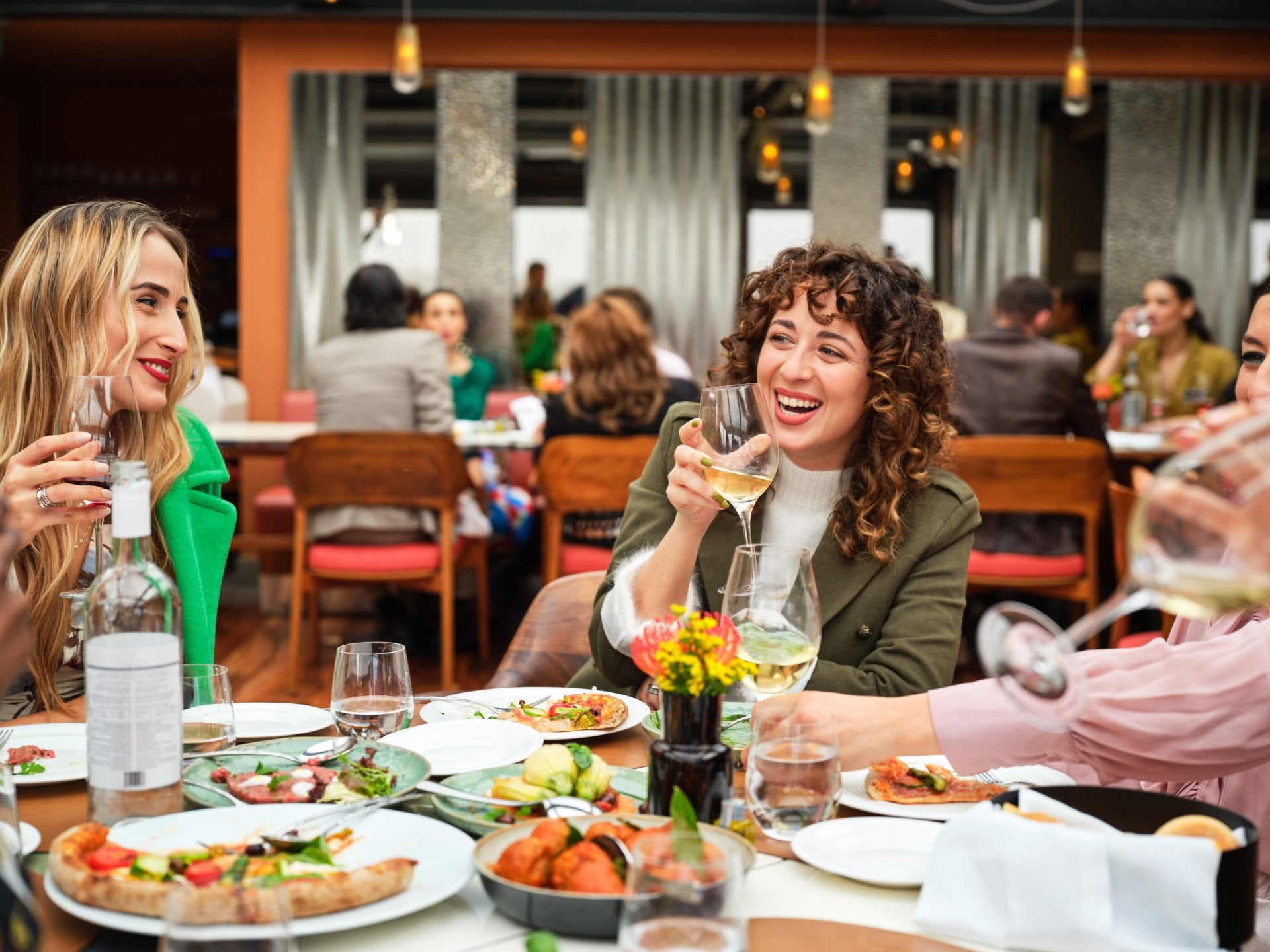 Giovani donne sorridenti che parlano e mangiano a Il Giardino Ristorante
