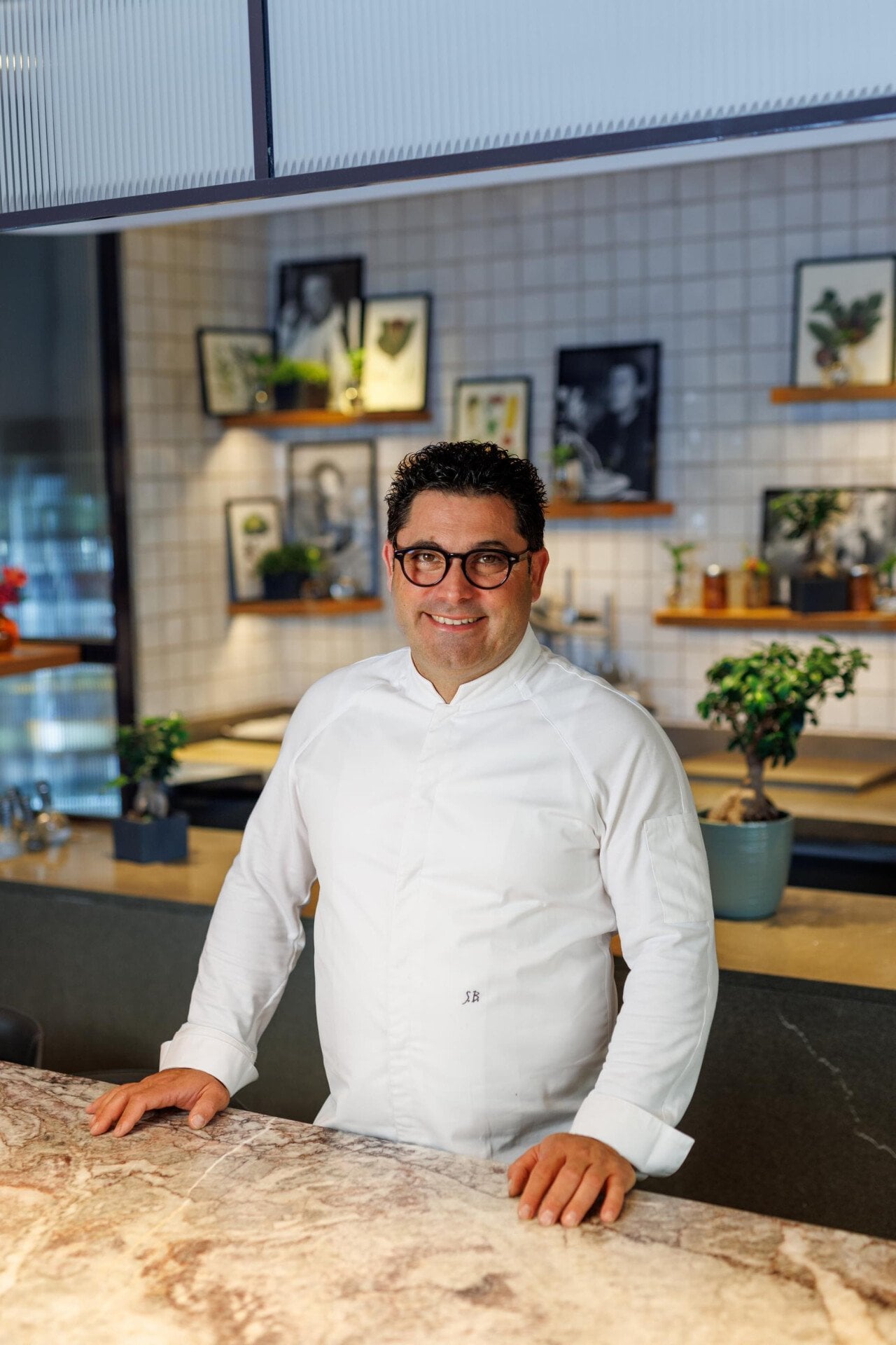 Ritratto di chef Salvatore Bianco al tavolo comune de Il Giardino Ristorante a Hotel Eden Roma