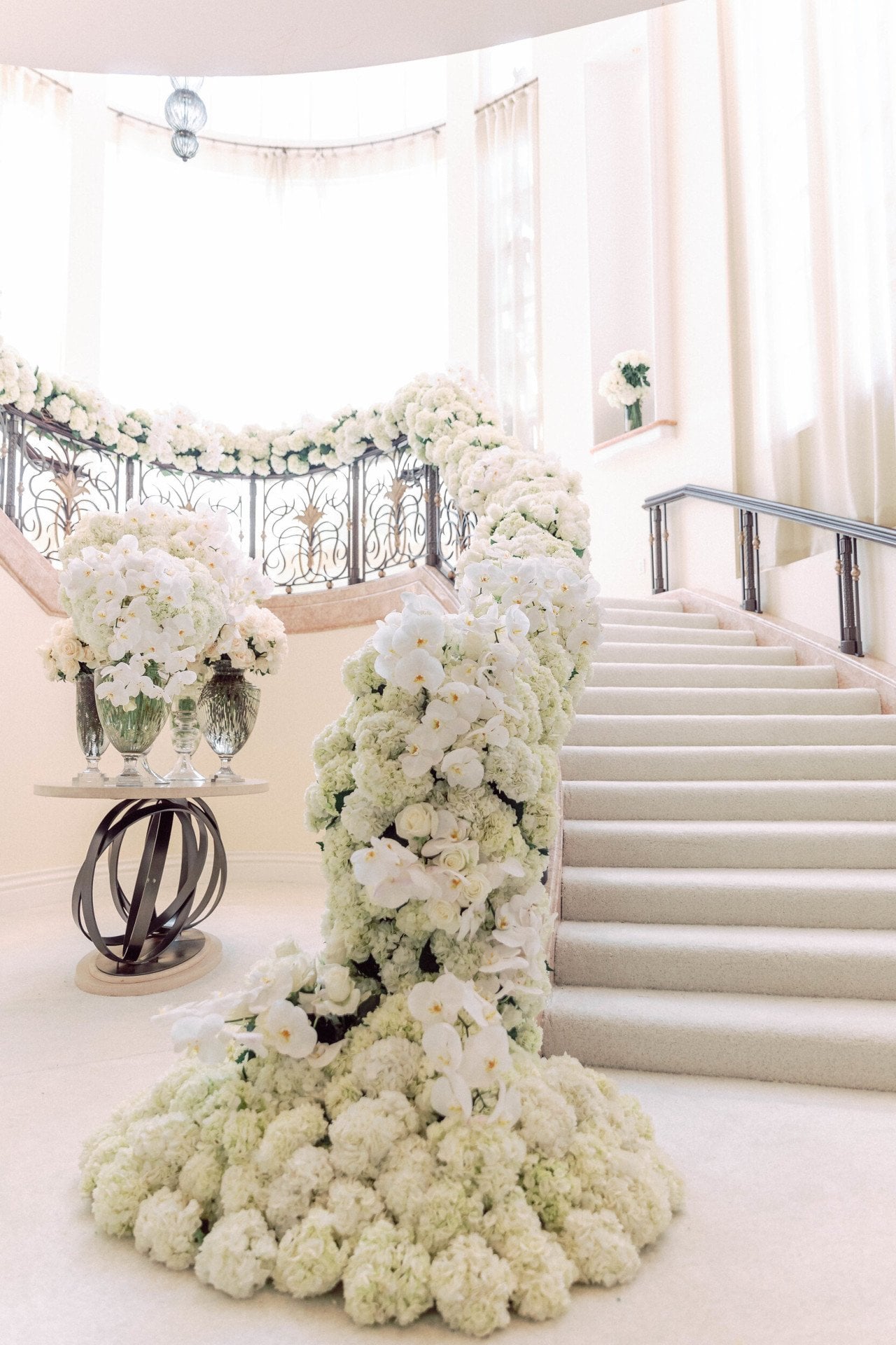 White florals cascading down grand staircase for wedding
