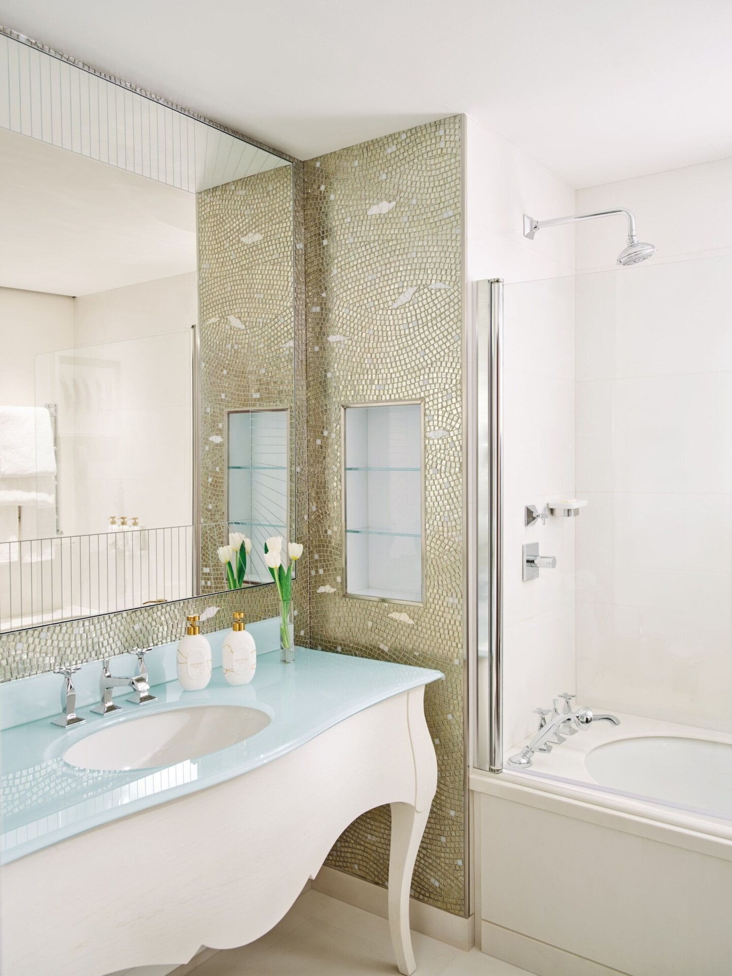 Bagno in marmo con tulipani bianchi e prodotti da bagno 