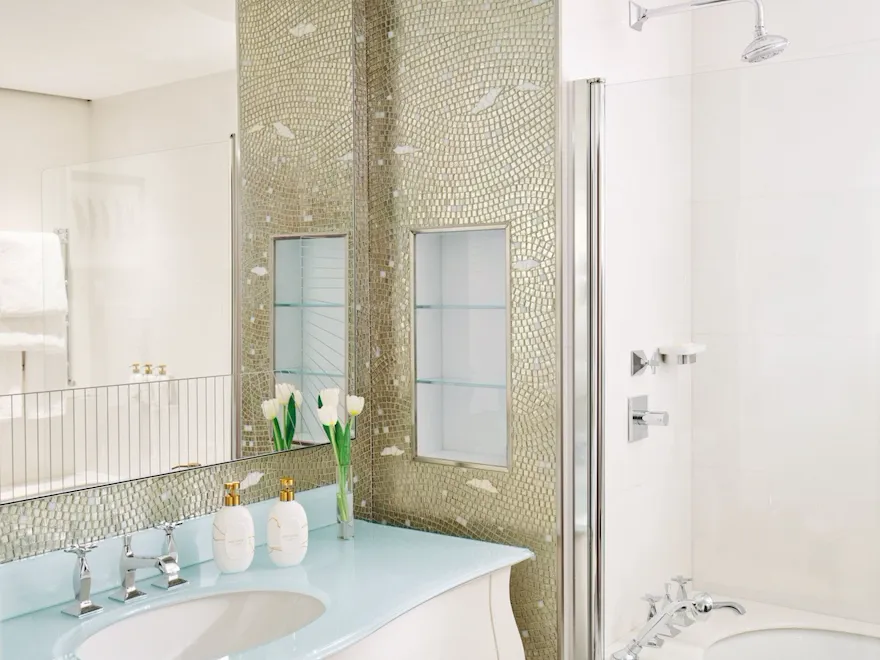 Bagno in marmo con tulipani bianchi e prodotti da bagno