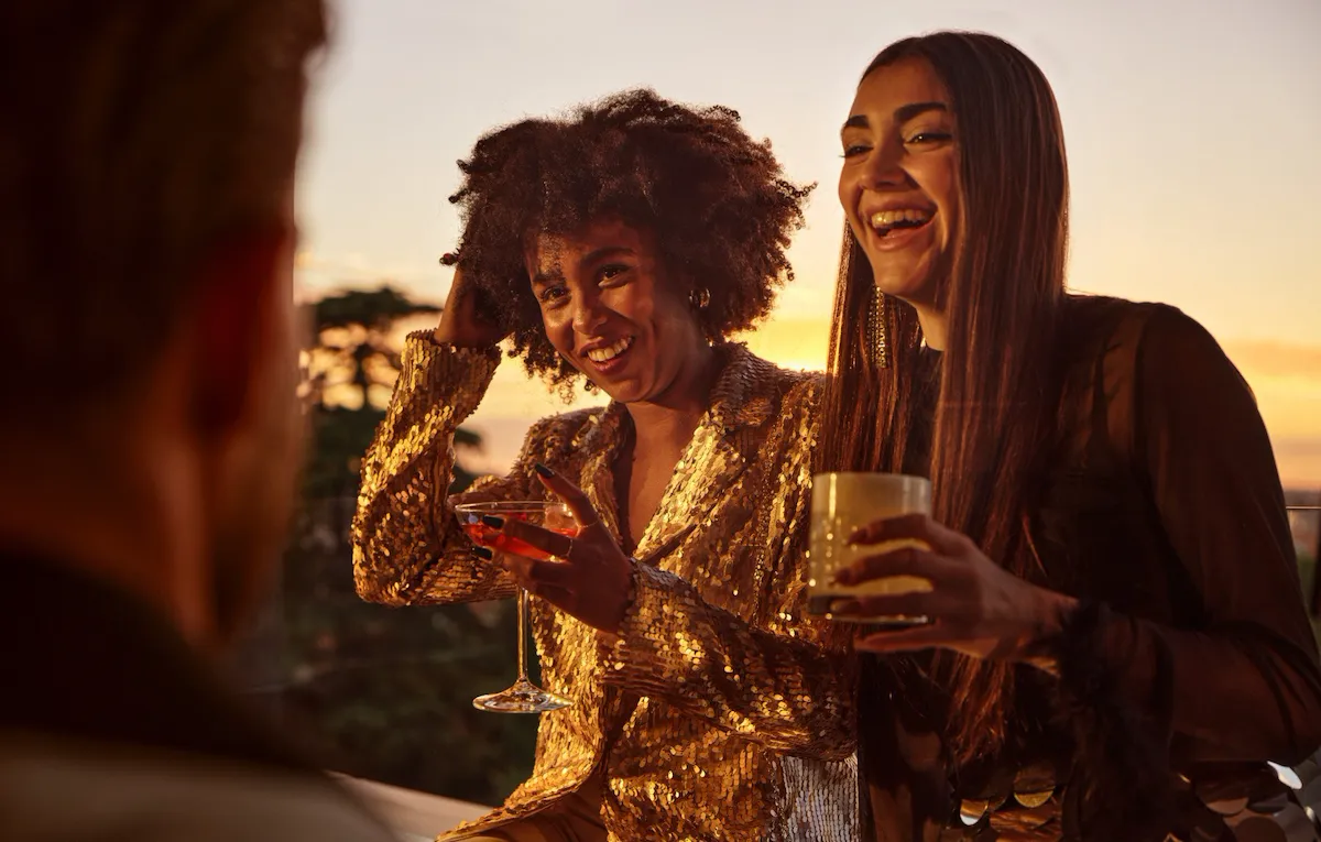 Due giovani donne sorridenti con un cocktail in mano a Il Giardino Bar