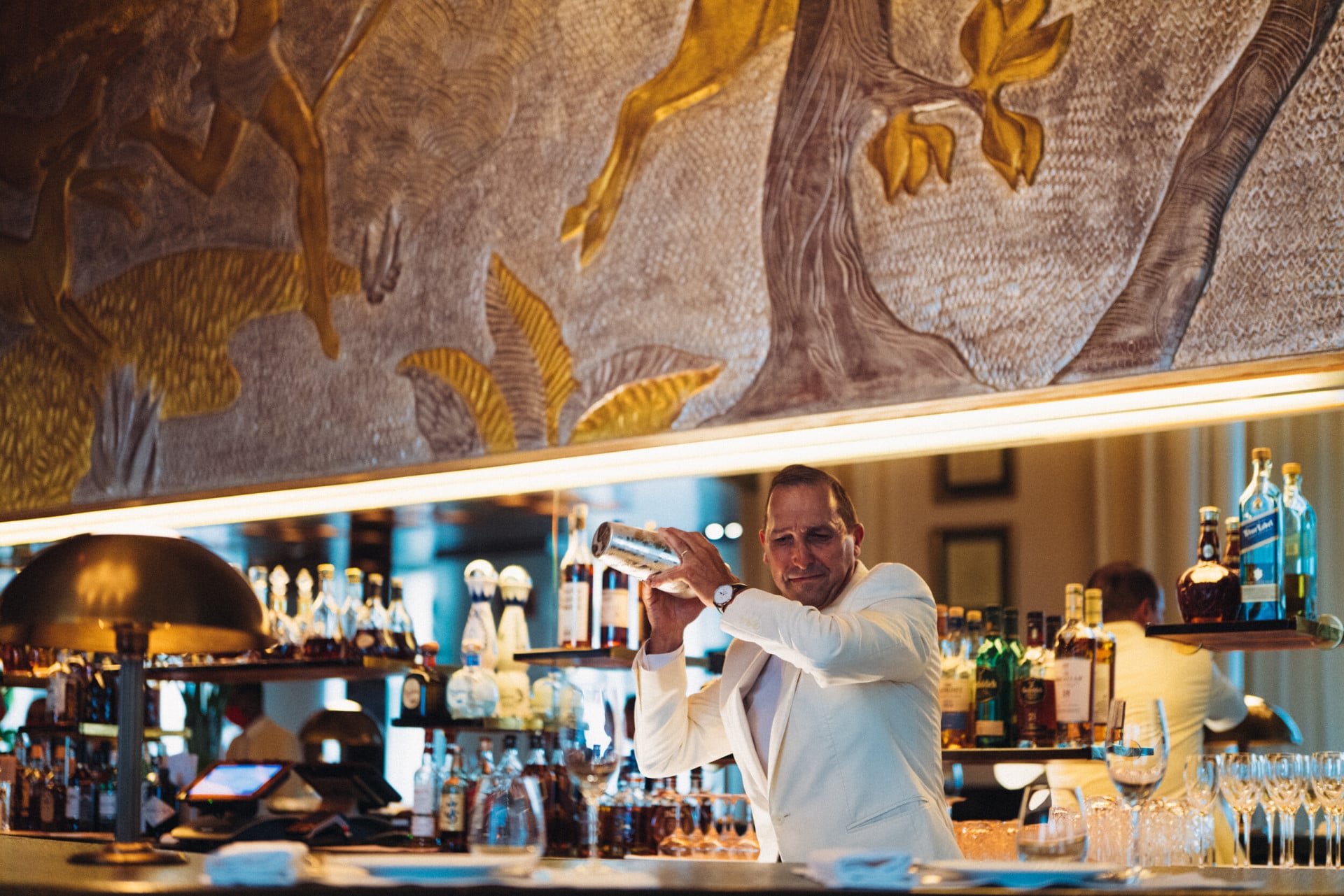 Le Relais Plaza bartender shaking a cocktail at the bar, at Hotel Plaza Athénée, Paris