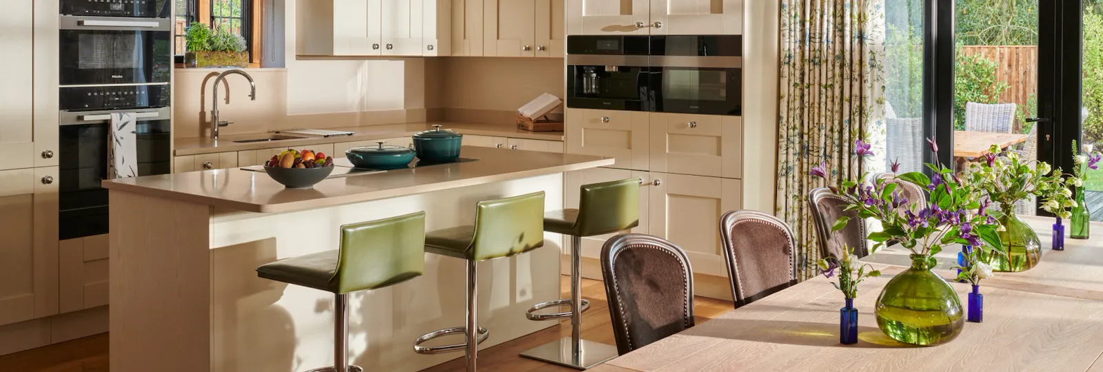 Bright kitchen with a dining area, flowers, and sliding glass doors to the garden.