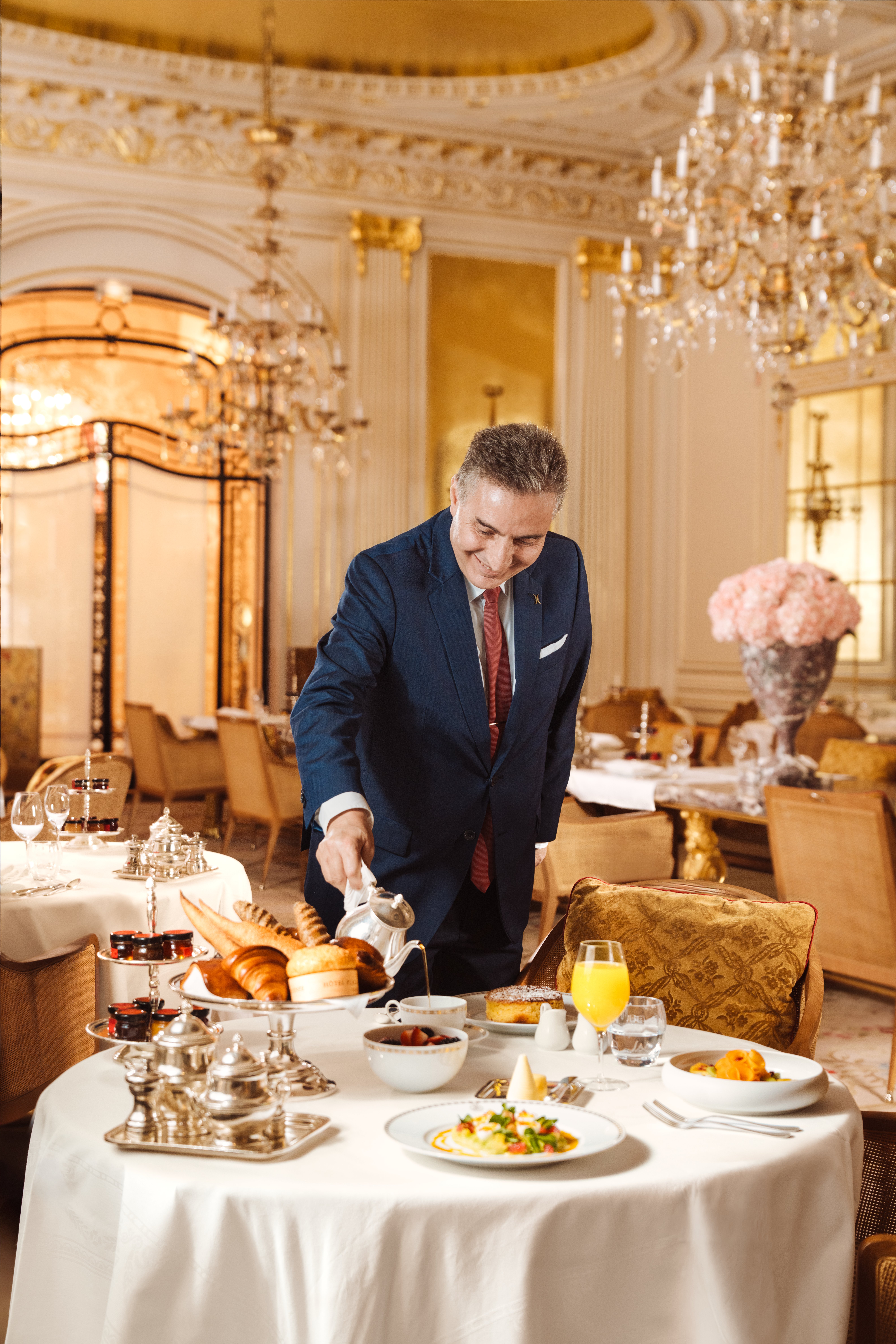 A waiter is pouring coffee in a cup for the brunch at Hotel Plaza Athénée