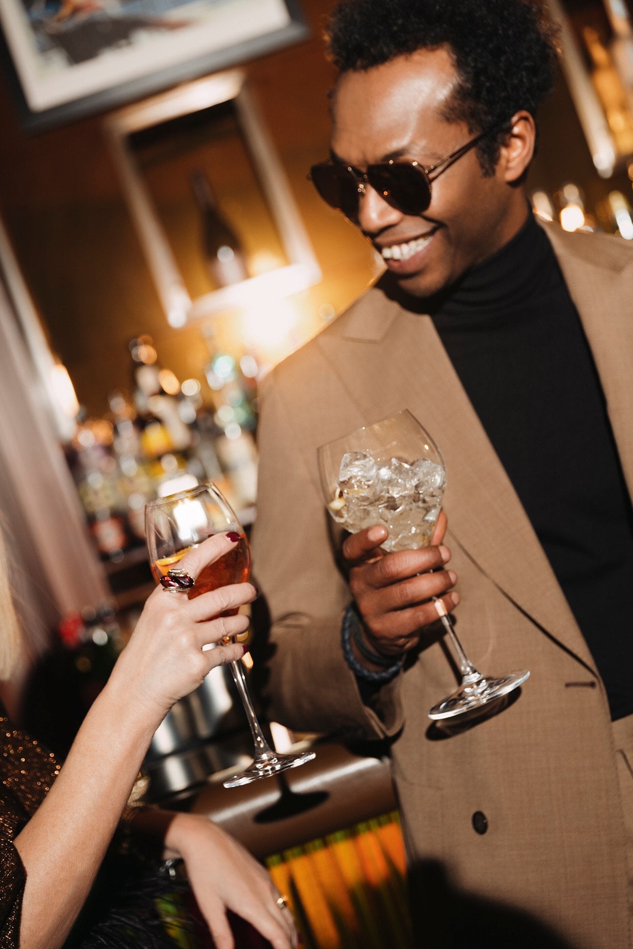 Detail of a male guest with sunglasses drinking during an event 