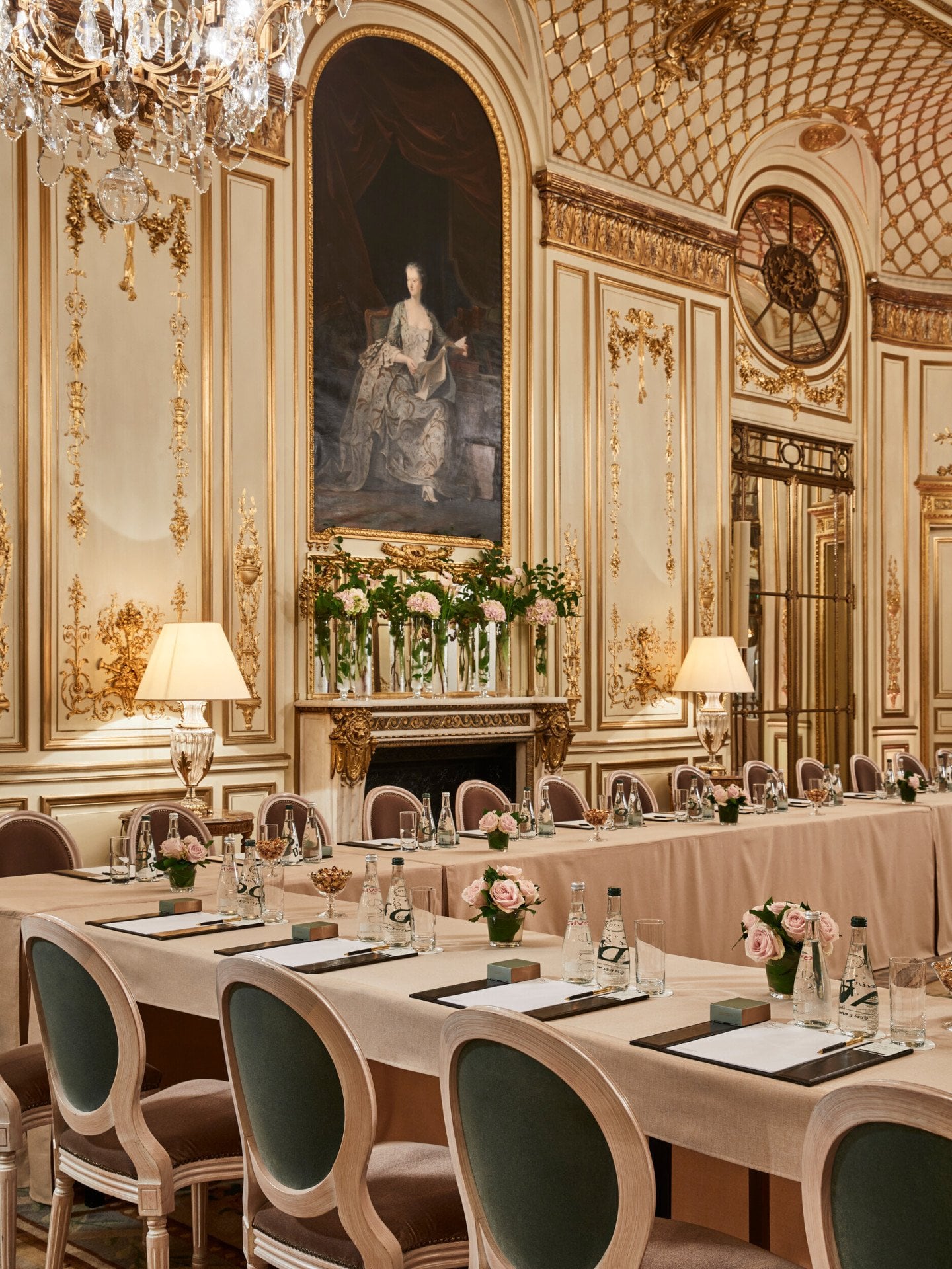 A Sala Pompadour foi transformada em uma sala de reuniões em forma de U. Nas mesas temos flores, papéis, canetas e garrafas de água, no Meurice, em Paris.