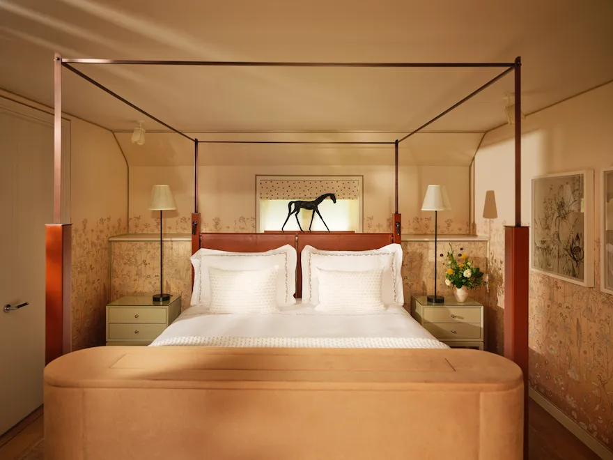 Four-poster bed with equestrian artwork in the Stable Junior Suite at Coworth Park in Ascot