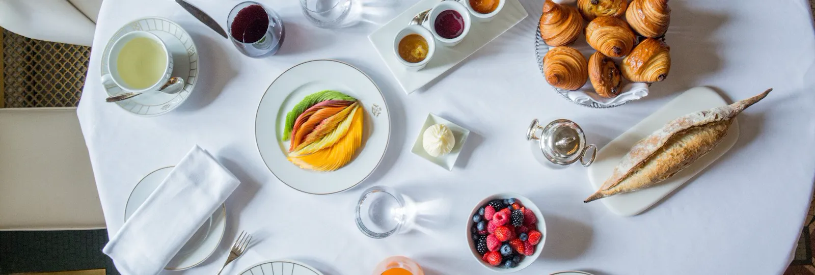 Top view of a breakfast table with sweet foods such as pancakes, fruits, crepes, pastries. At Le Meurice, Paris.