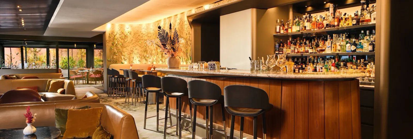 Interno de Il Giardino Bar con lungo bancone illuminato e ampie finestre