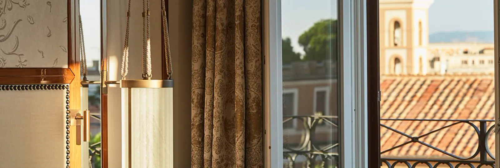 Dettaglio di una camera con finestra aperta su balcone con vista su Roma a Hotel Eden Roma
