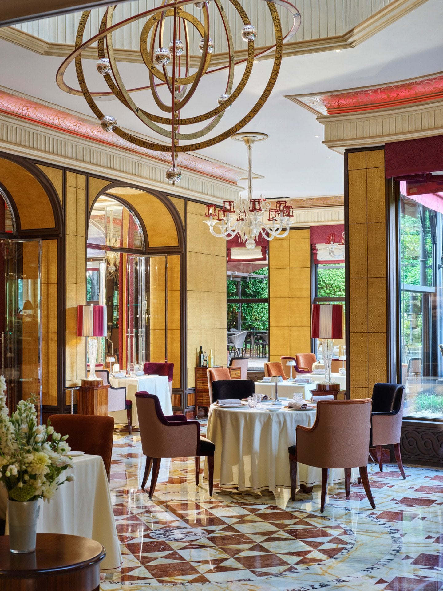 Acanto restaurant interior. Tables, chairs and garden in the background