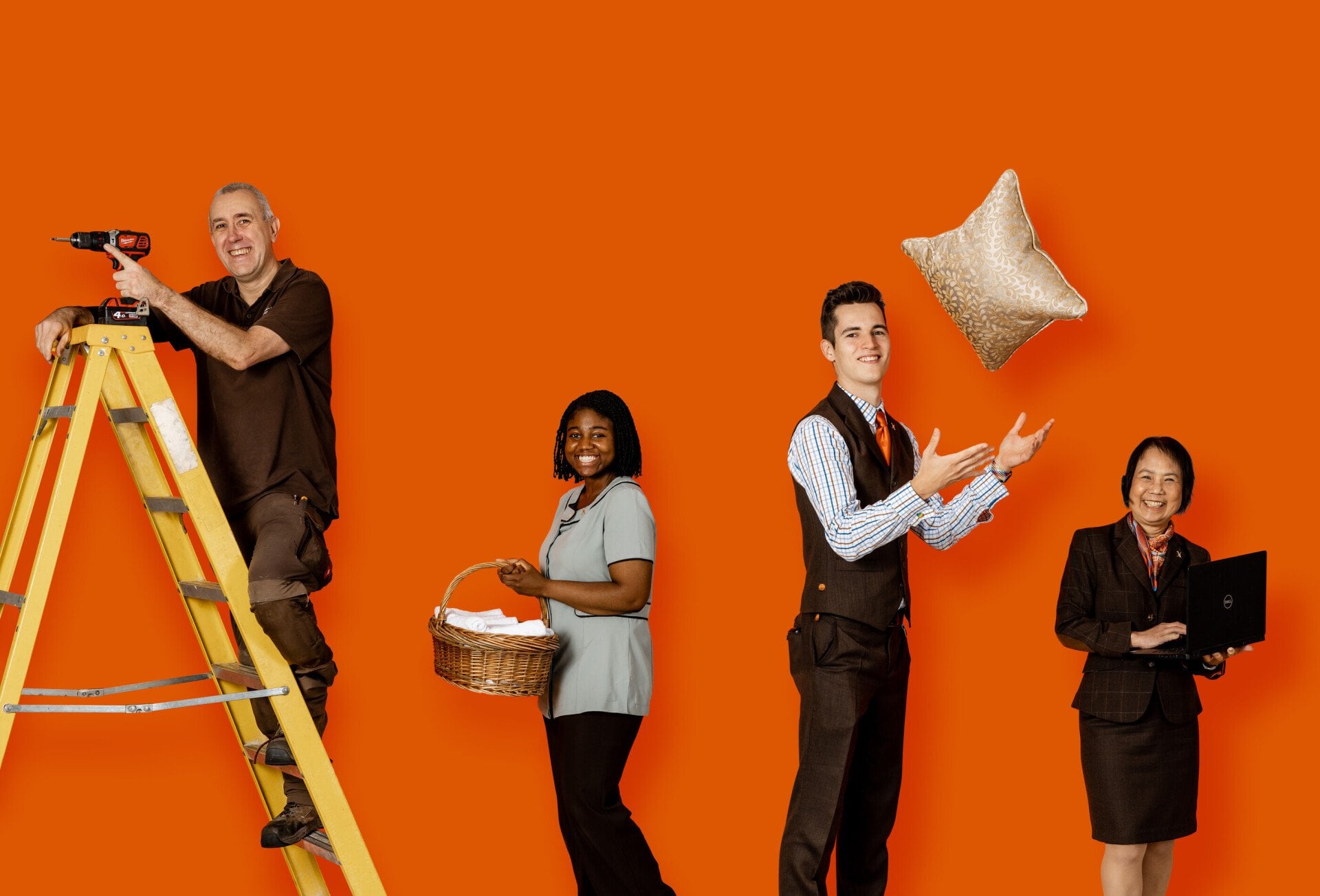 Group of people holding various items used by the rooms division at a hotel 