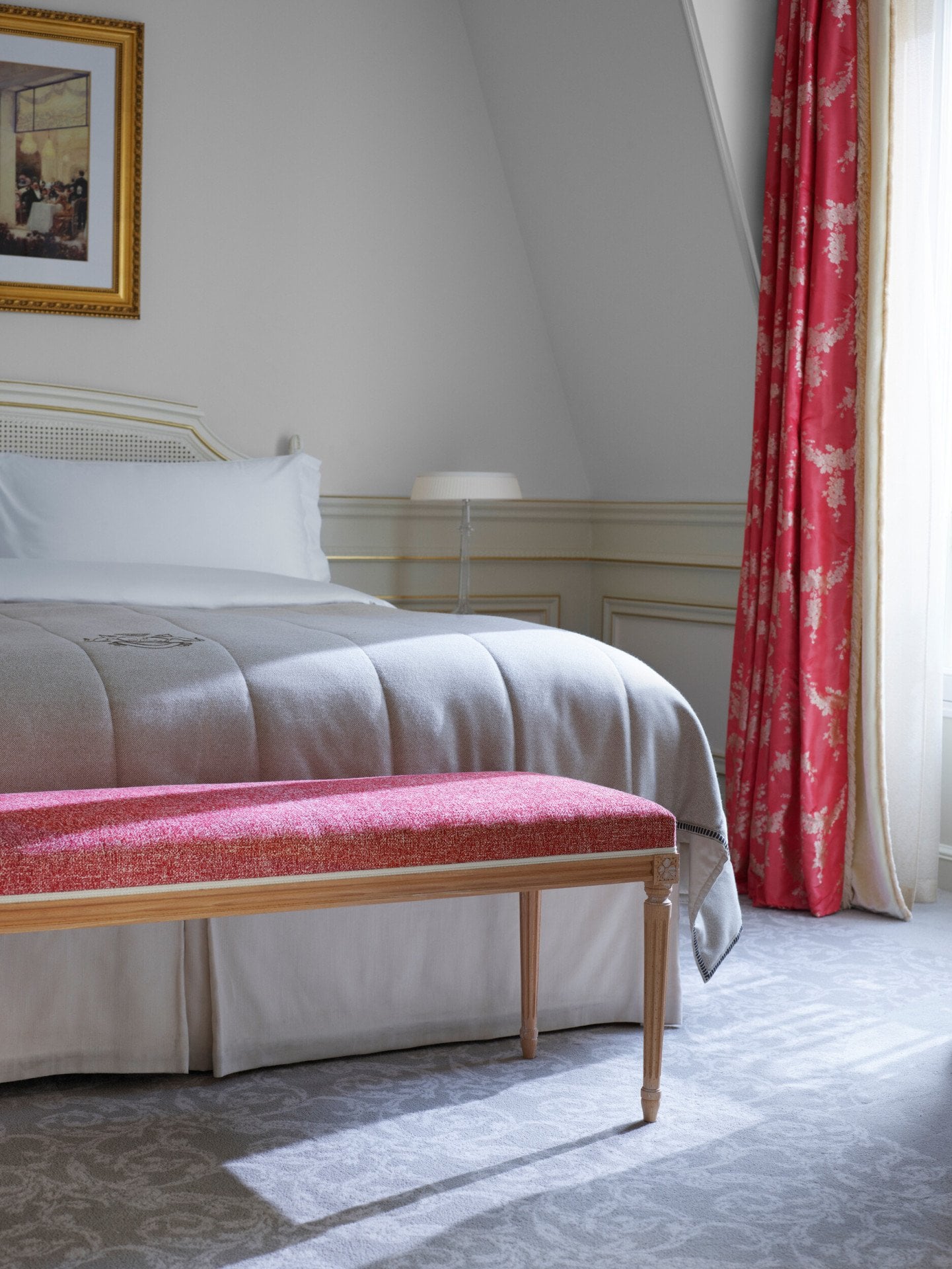 Gros plan du lit et du banc devant dans la chambre d'une suite junior exécutive au Meurice, Paris.
