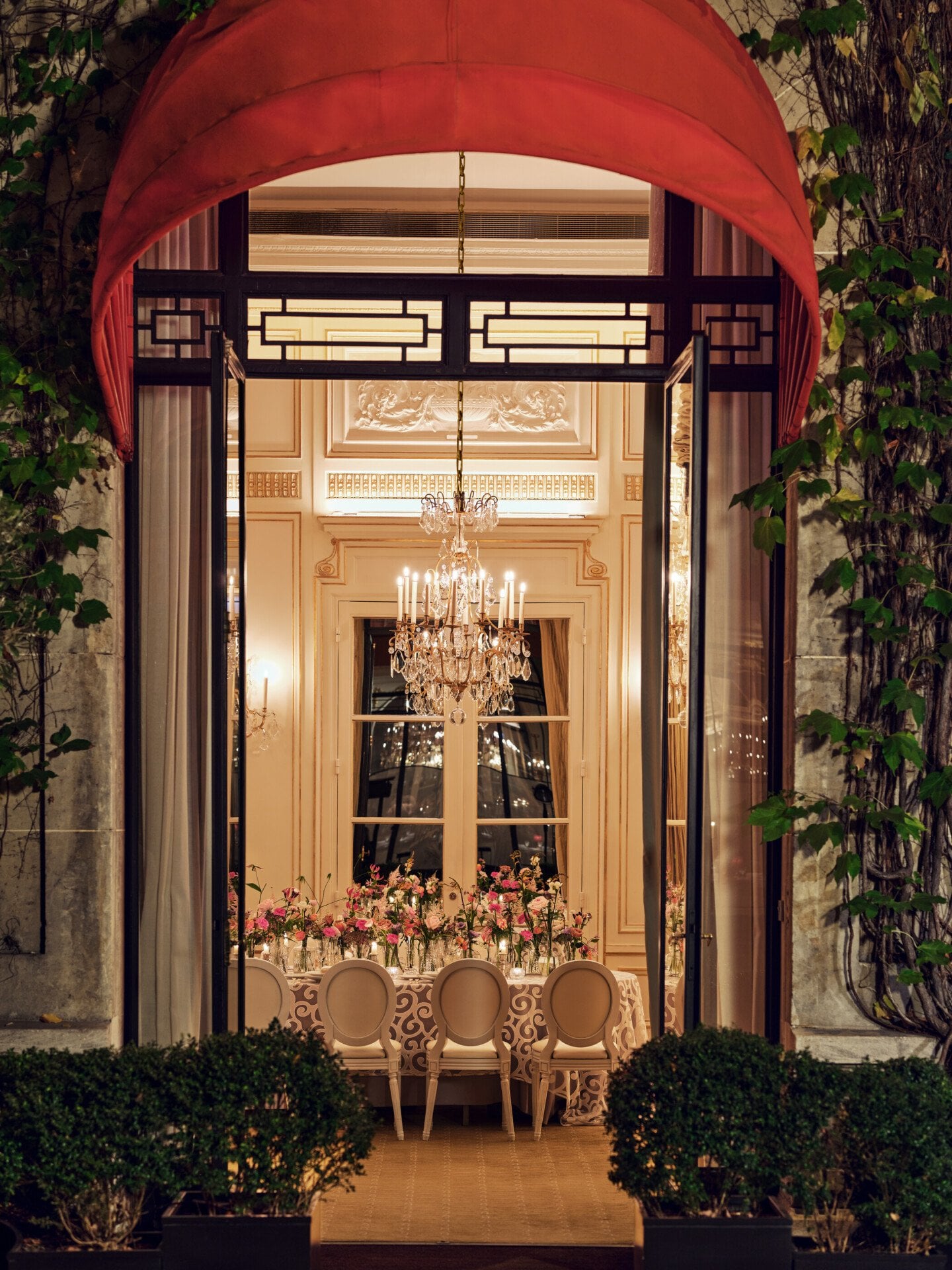 Table captured from outside with colorful flower arrangement at  Le Salon Organza, Hôtel Plaza Athénée, Paris - Dorchester Collection.