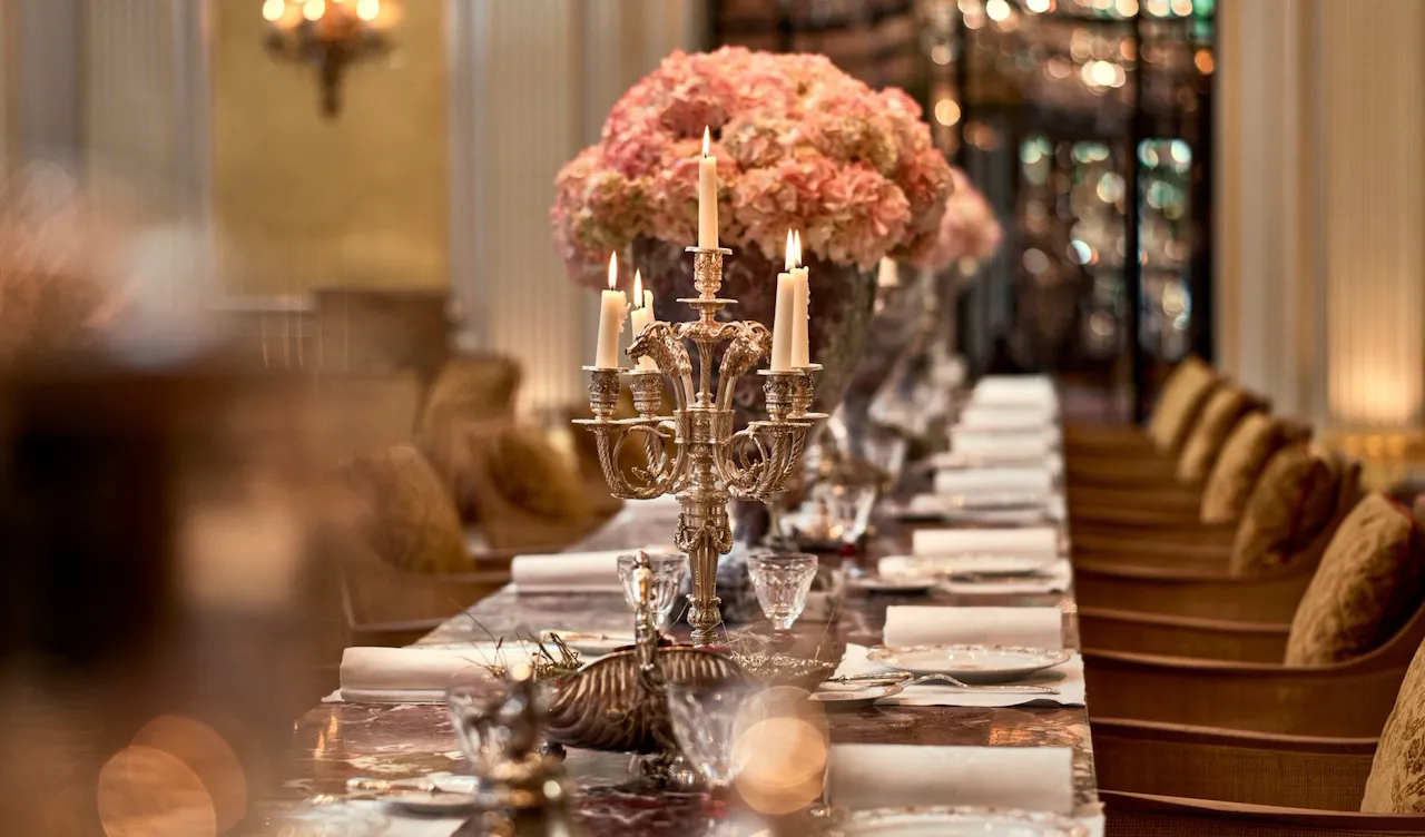 Jean Imbert au Plaza Athénée : la table centrale en marbre, agrémentée de fleurs roses et de chandeliers. A l'hôtel Plaza Athénée, Paris