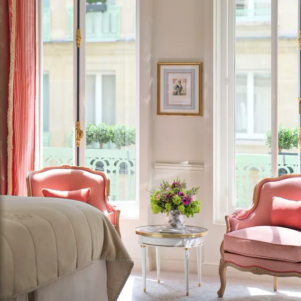 Realce de um quarto de luxo com vista para as cadeiras a condizer com o cortinado em frente às janelas, no Le Meurice, Paris