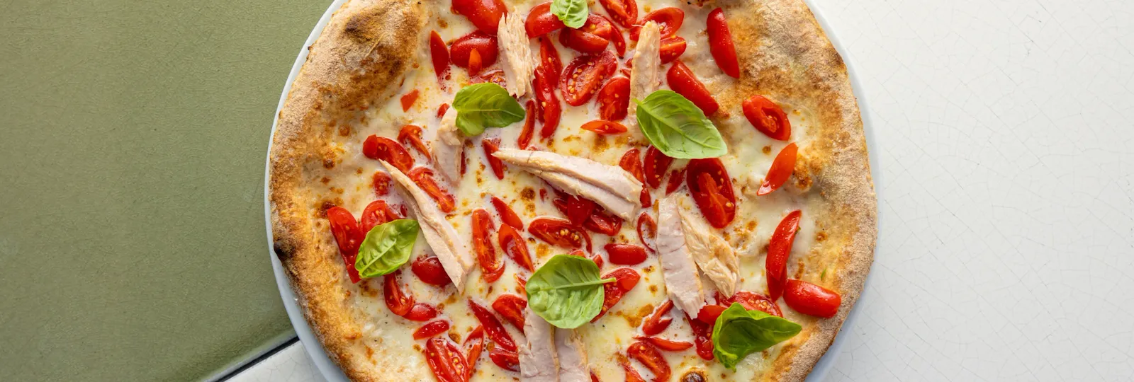 Pizza seasoned with cherry tomatoes, mozzarella of buffalo, tuna, and basil at Il Giardino Ristorante, Hotel Eden in Rome