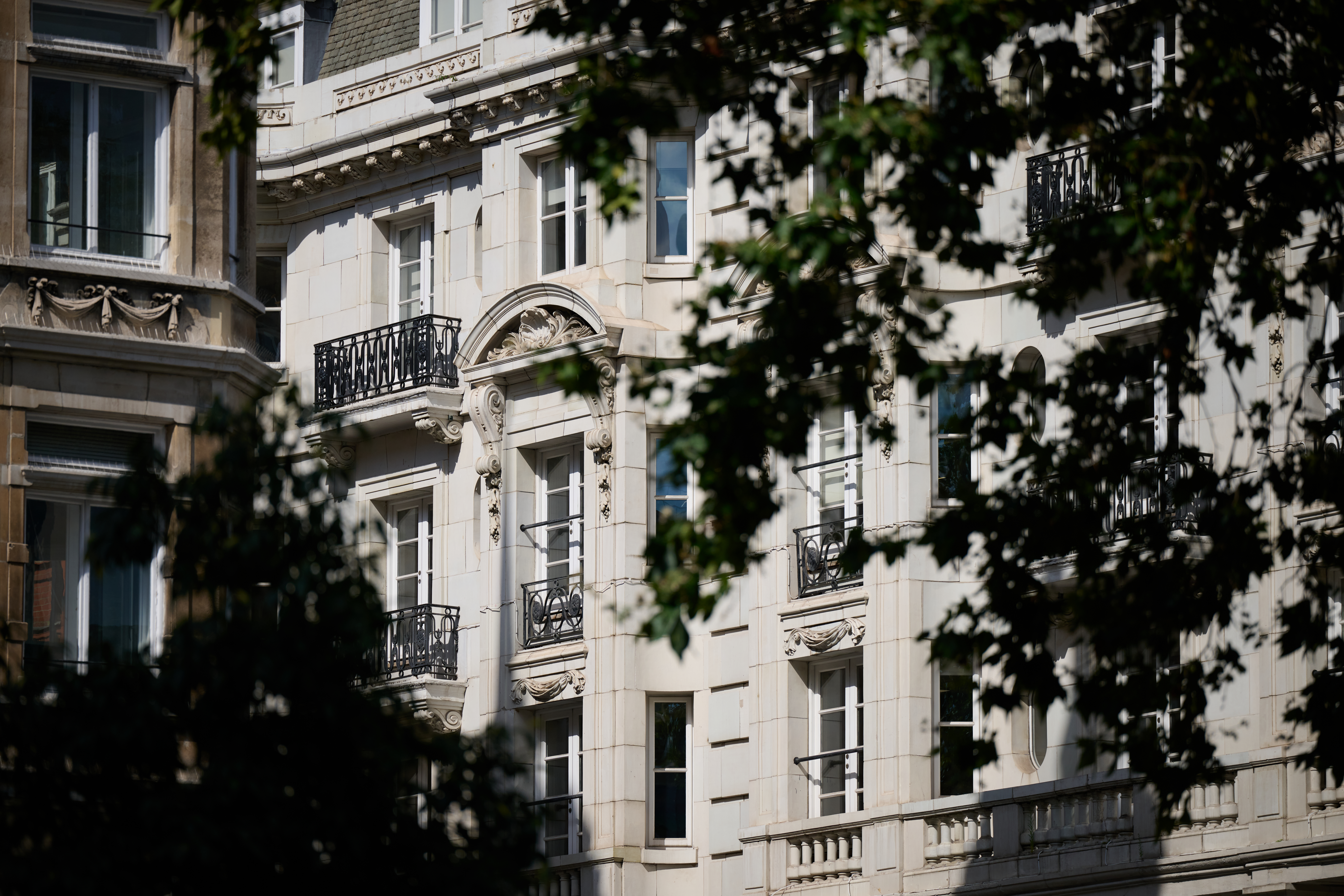  the ornate stone facade of a classic Parisian apartment building