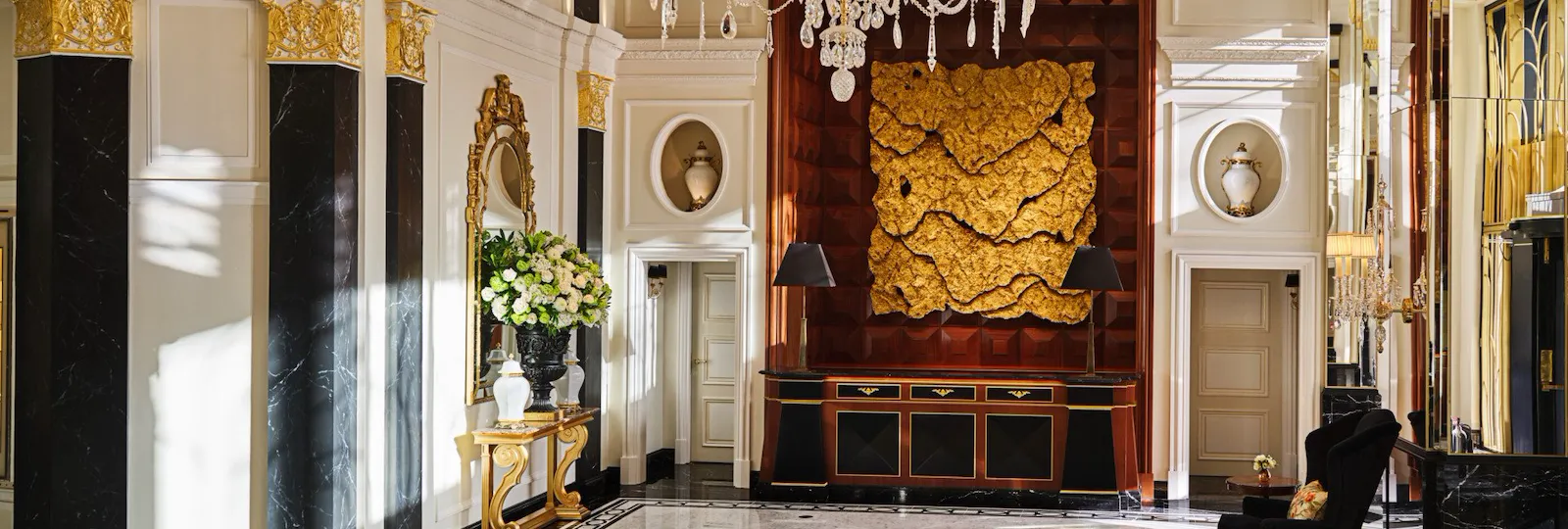 The Dorchester Lobby with reception desk and concierge desk in afternoon sunlight
