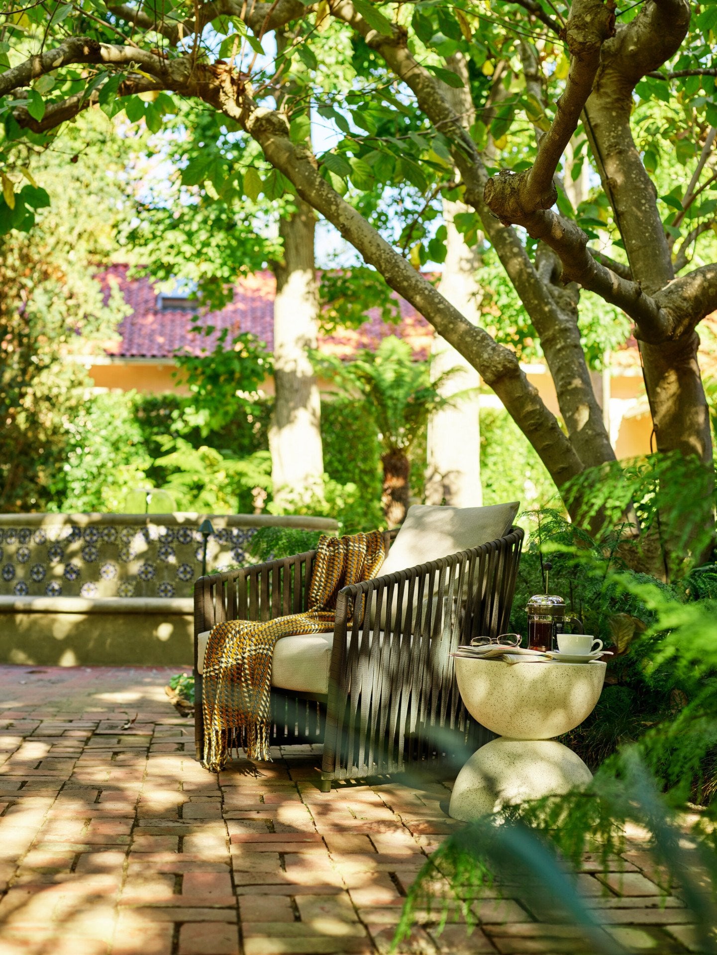 Garden chair in the gardens of Hotel Bel-Air with dappled sunlight, Los Angeles