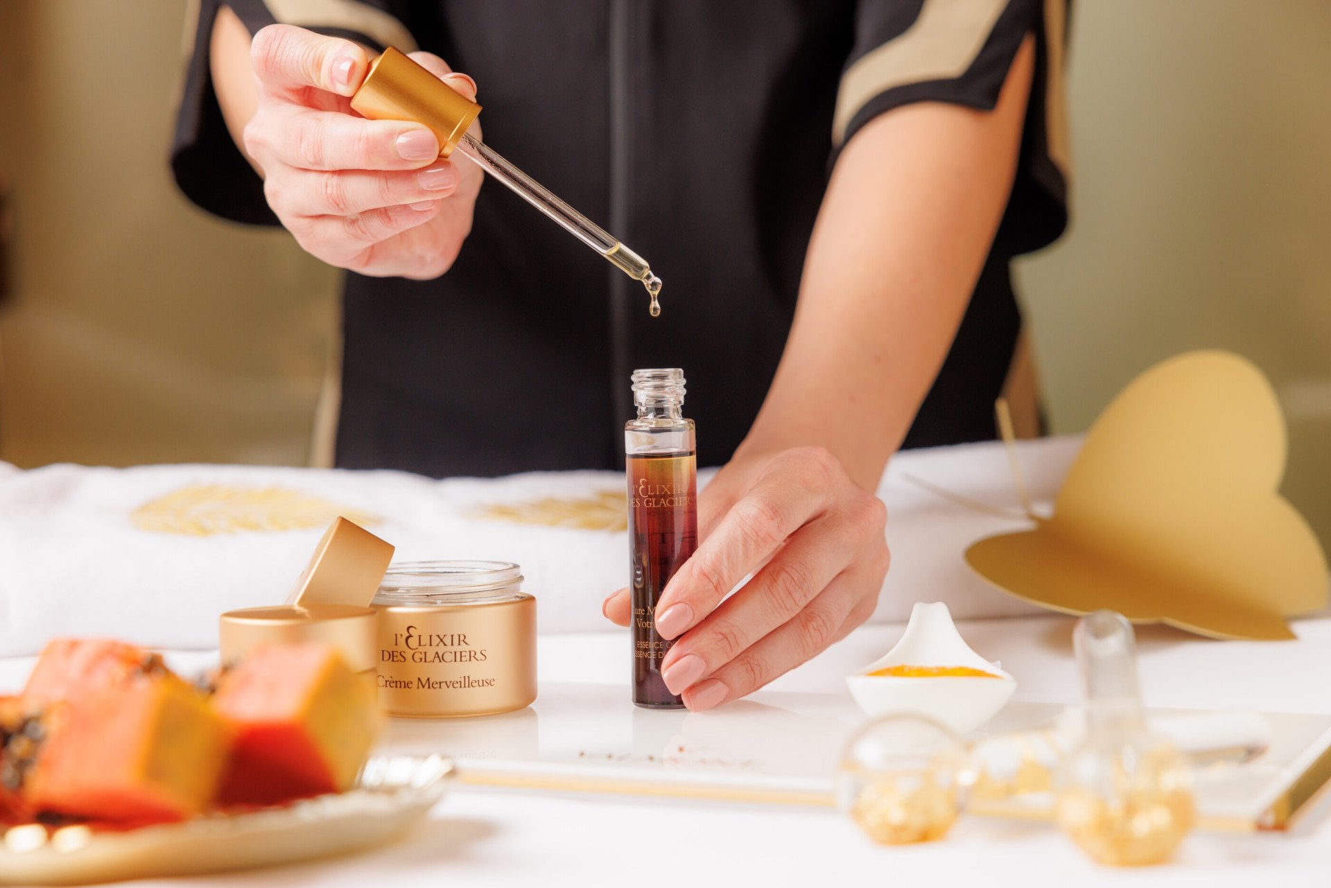 Dettaglio delle mani di una terapista che dosa con contagocce Elixir des Glaciers di Valmont
