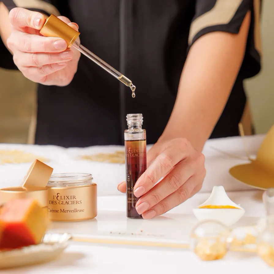 Dettaglio delle mani di una terapista che dosa con contagocce Elixir des Glaciers di Valmont