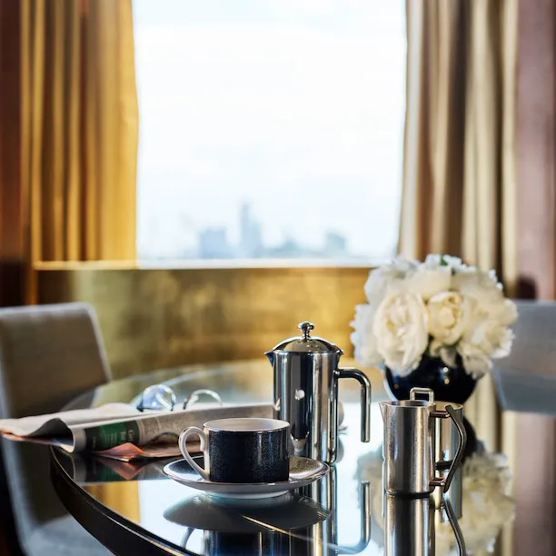 Penthouse Suite-living room_ beautiful daylight, coffee and newspaper on the dining table