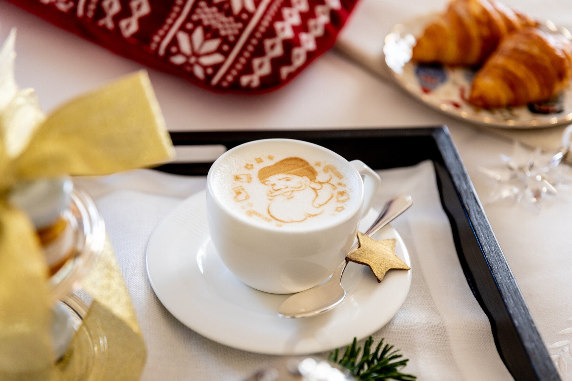Cappuccino with Santa Claus image and croissants in the background at Hotel Eden, Rome